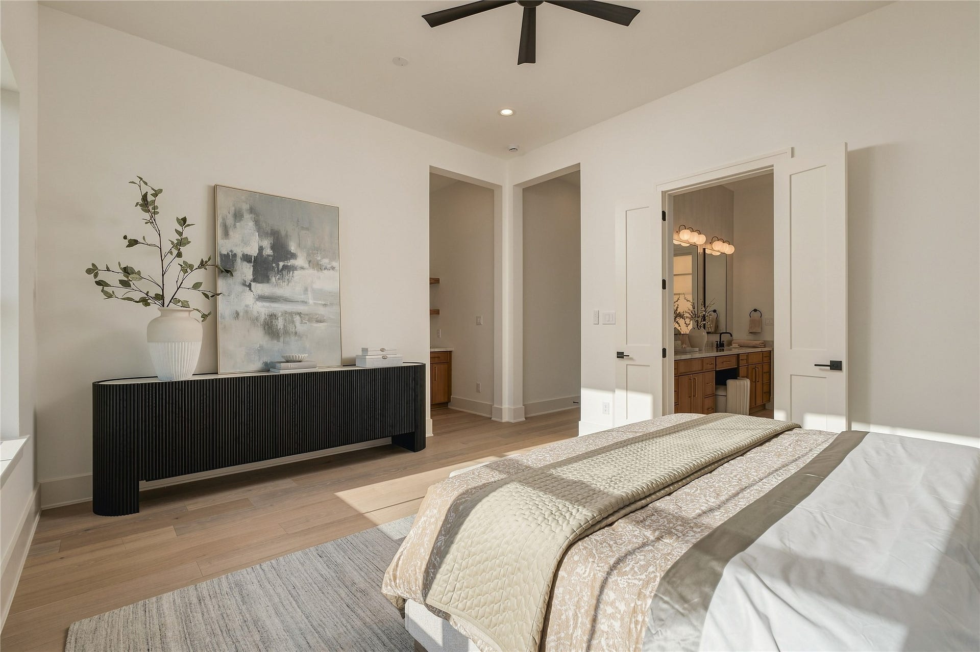 2107 McKean Drive, Houston, TX 77080 A second perspective of the primary suite reveals its private connection to the ensuite bath and dual custom closets, creating a retreat designed with both comfort and function in mind. *BATHROOM CABINET COLOR VARIED, MODEL HOME PHOTO*