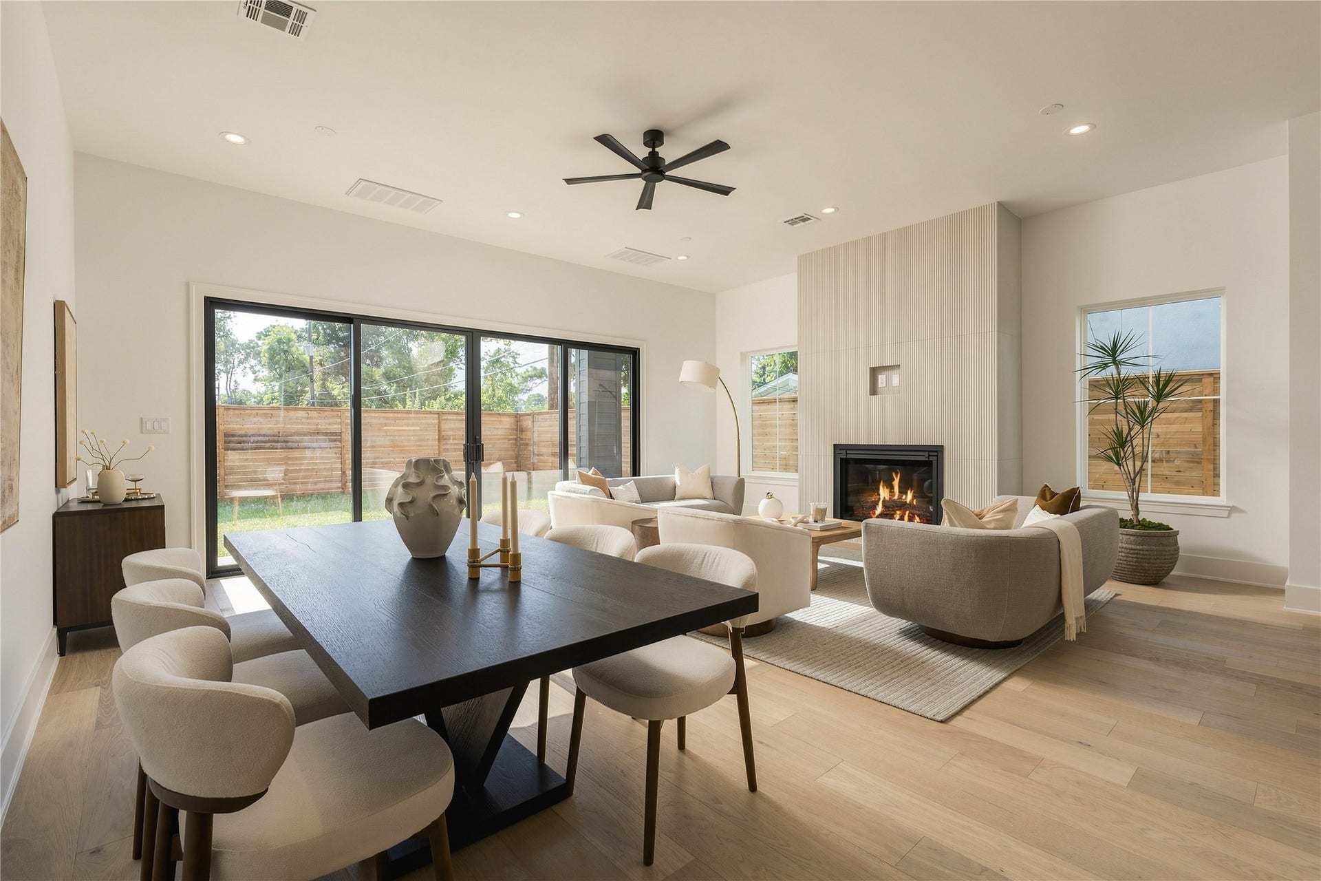 2107 McKean Drive, Houston, TX 77080 *MODEL HOME PHOTO* A cohesive living and dining space defined by clean lines, soft natural tones, and an elegant fireplace.