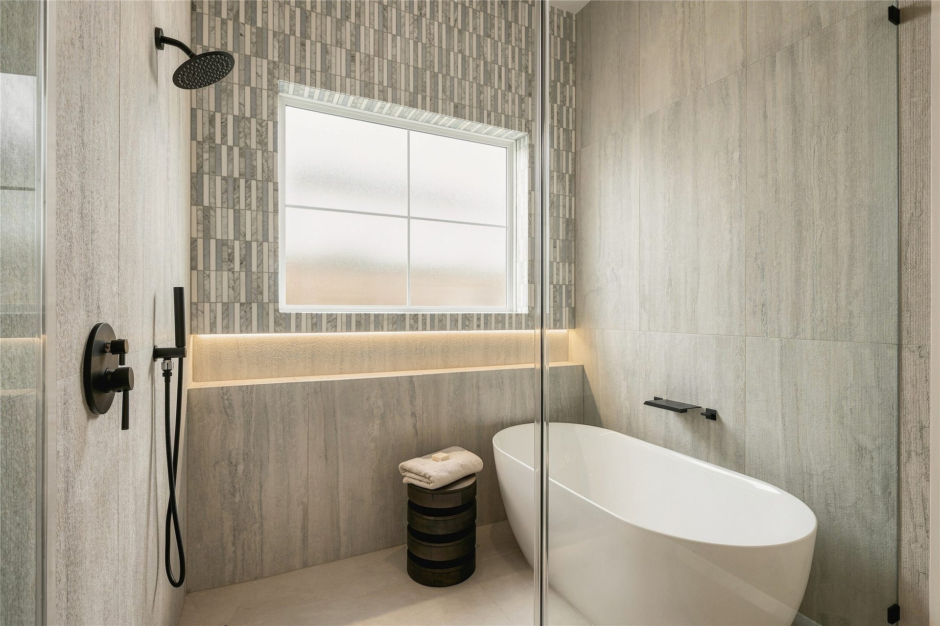2107 McKean Drive, Houston, TX 77080 A private water closet is finished with full-height designer tile and natural light, carrying the primary baths refined material palette through every detail.