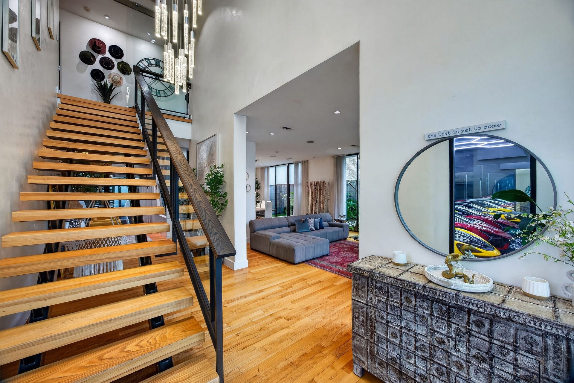 1310 Nantucket Drive, Houston, TX 77057 Stunning open-concept entryway featuring a modern floating staircase with sleek wood and metal design, leading to a spacious living area with stylish decor and abundant natural light.