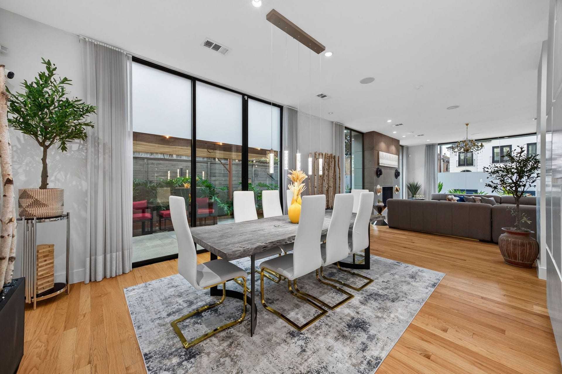 1310 Nantucket Drive, Houston, TX 77057 Experience modern elegance in this open-concept living and dining area, featuring floor-to-ceiling windows that flood the space with natural light and offer seamless indoor-outdoor flow.