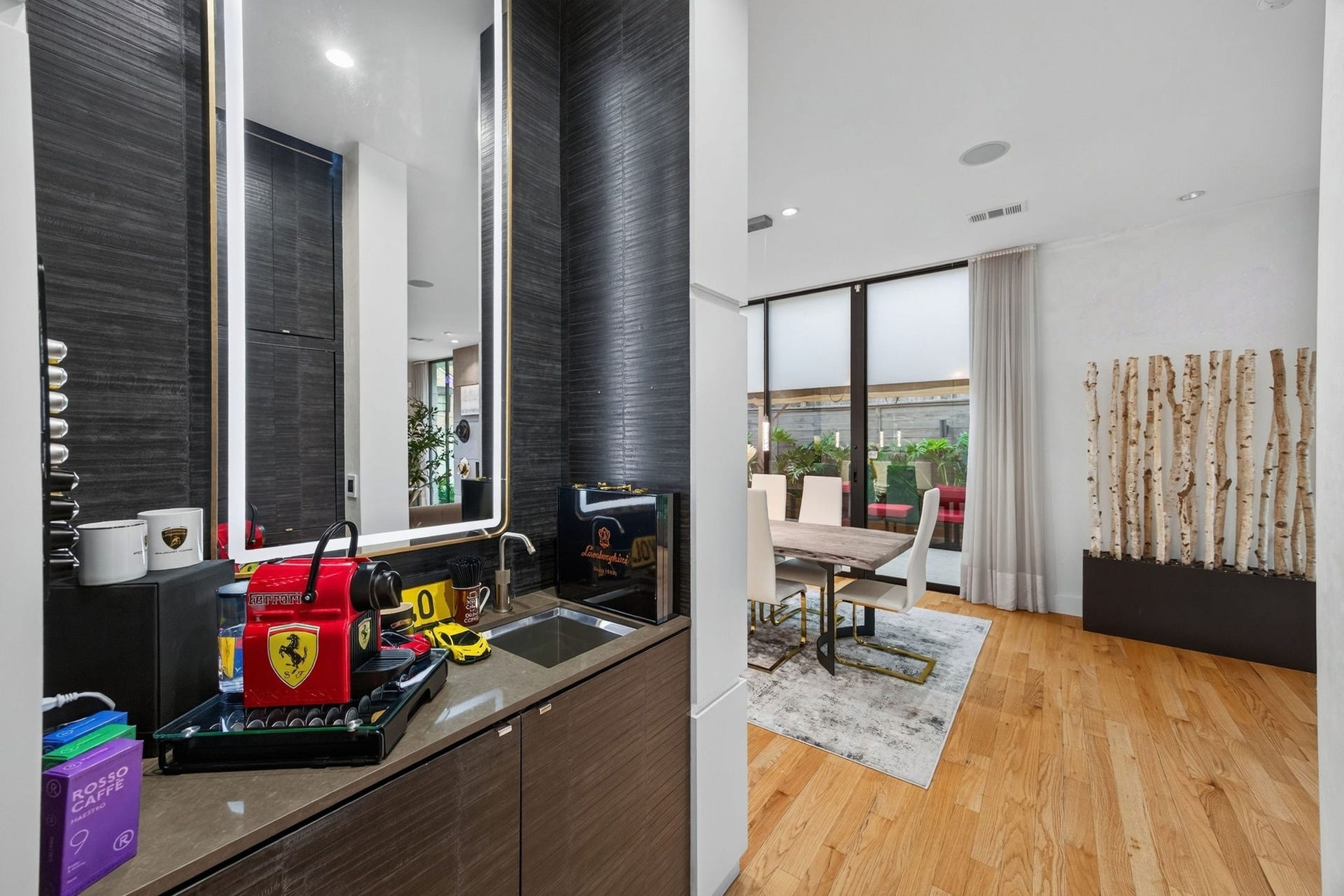 1310 Nantucket Drive, Houston, TX 77057 Sleek modern kitchen with a stylish coffee station, complemented by a cozy dining area featuring large windows and natural light.