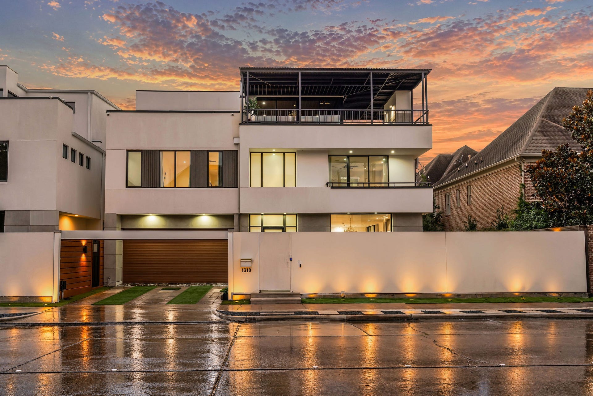 1310 Nantucket Drive, Houston, TX 77057 Modern three-story home with sleek lines, expansive windows, and a spacious rooftop terrace, set against a stunning sunset sky.