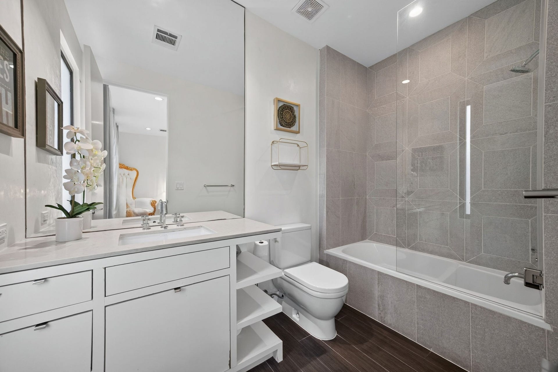 1310 Nantucket Drive, Houston, TX 77057 Sleek and modern bathroom featuring a spacious vanity with ample storage, elegant fixtures, and a luxurious bathtub with a glass enclosure.