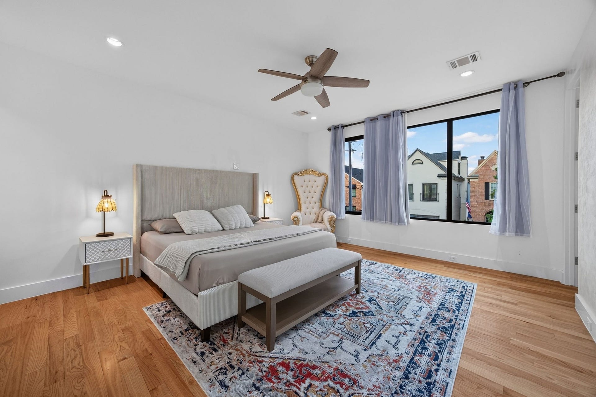 1310 Nantucket Drive, Houston, TX 77057 Spacious and elegant bedroom featuring a large window with abundant natural light, hardwood floors, and a stylish ceiling fan.