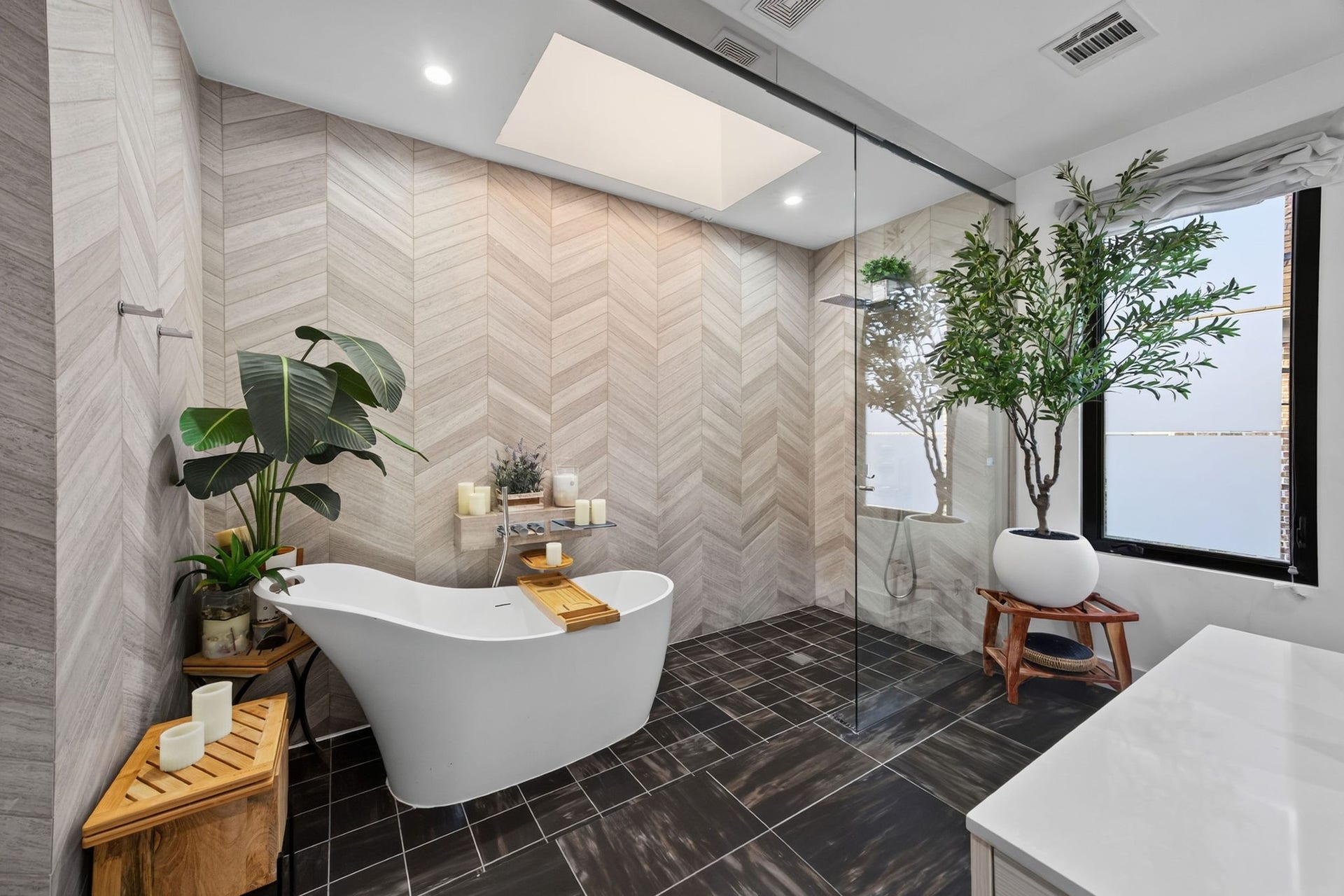 1310 Nantucket Drive, Houston, TX 77057 Luxurious bathroom featuring a freestanding tub, elegant chevron-patterned walls, and a spacious glass-enclosed shower.