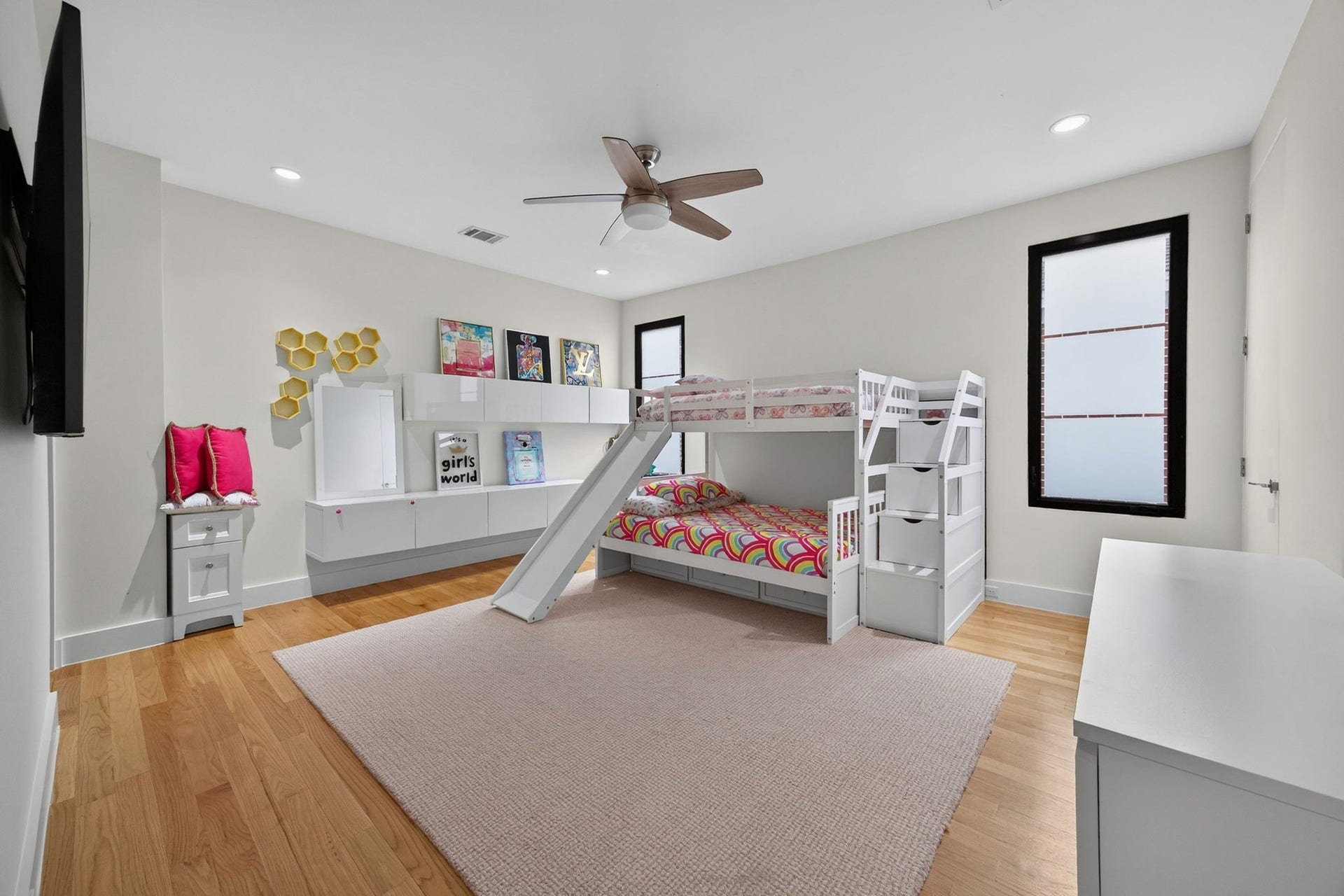 1310 Nantucket Drive, Houston, TX 77057 Bright and airy bedroom with a stylish bunk bed featuring a slide, hardwood floors, and modern decor.