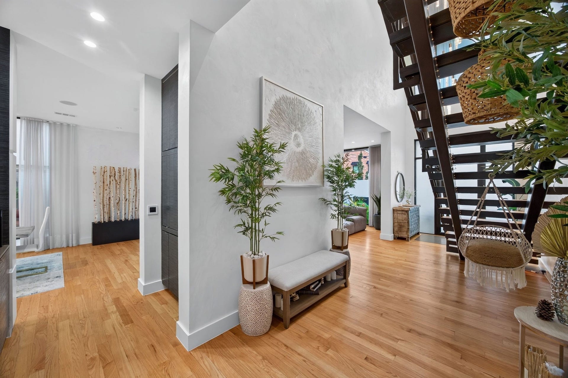 1310 Nantucket Drive, Houston, TX 77057 Bright and inviting entryway featuring sleek hardwood floors, modern open staircase, and stylish decor, offering a glimpse into the adjacent living spaces.