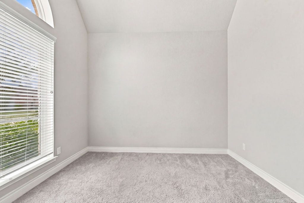 6914 Red Oak Drive, Katy, TX 77493 Bright and airy room with soft carpeting and a large window offering plenty of natural light, perfect for a cozy retreat or home office.