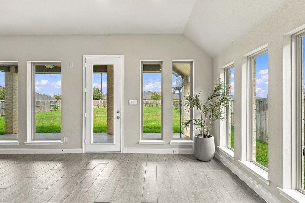 6914 Red Oak Drive, Katy, TX 77493 Bright and inviting room with expansive windows offering abundant natural light and a seamless view of the lush backyard, perfect for relaxation or entertaining.