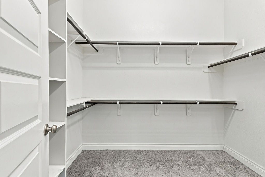6914 Red Oak Drive, Katy, TX 77493 Spacious walk-in closet with ample shelving and hanging space, perfect for organized storage.