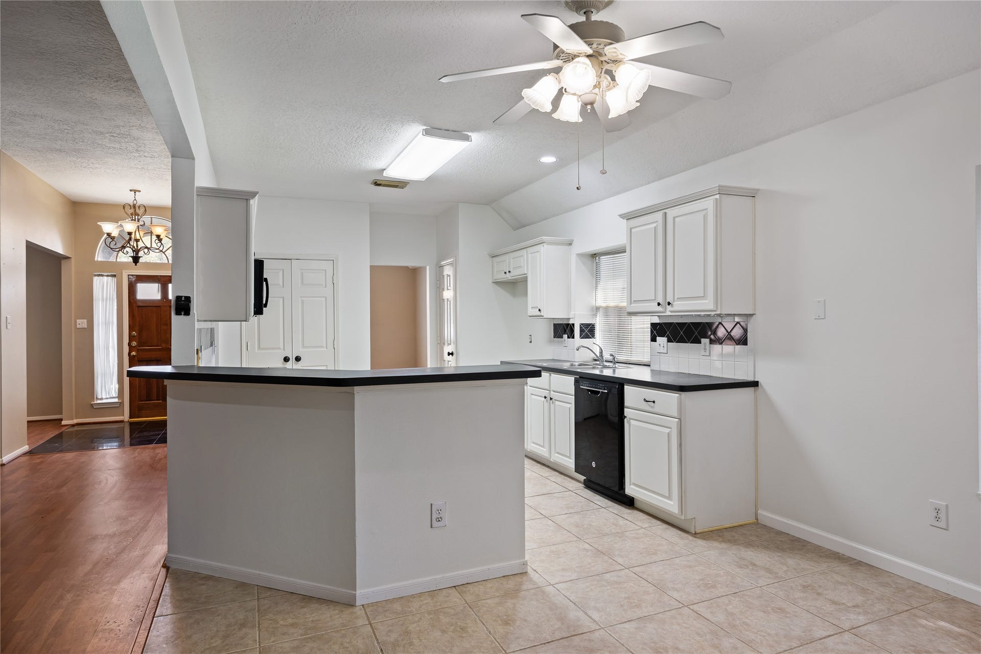16926 Cobbler Crossing Drive, Sugar Land, TX 77498 Classic black and white gives this kitchen a clean, timeless feel, while the wraparound bar opens to the living area and casual dining space to keep everyone connected.