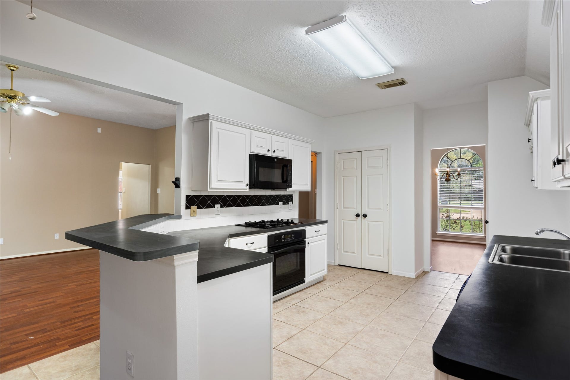 16926 Cobbler Crossing Drive, Sugar Land, TX 77498 This kitchen is designed to keep daily life moving with ample counter space, TWO PANTRIES and sleek black appliances including a gas oven and cooktop, built in microwave and dishwasher.