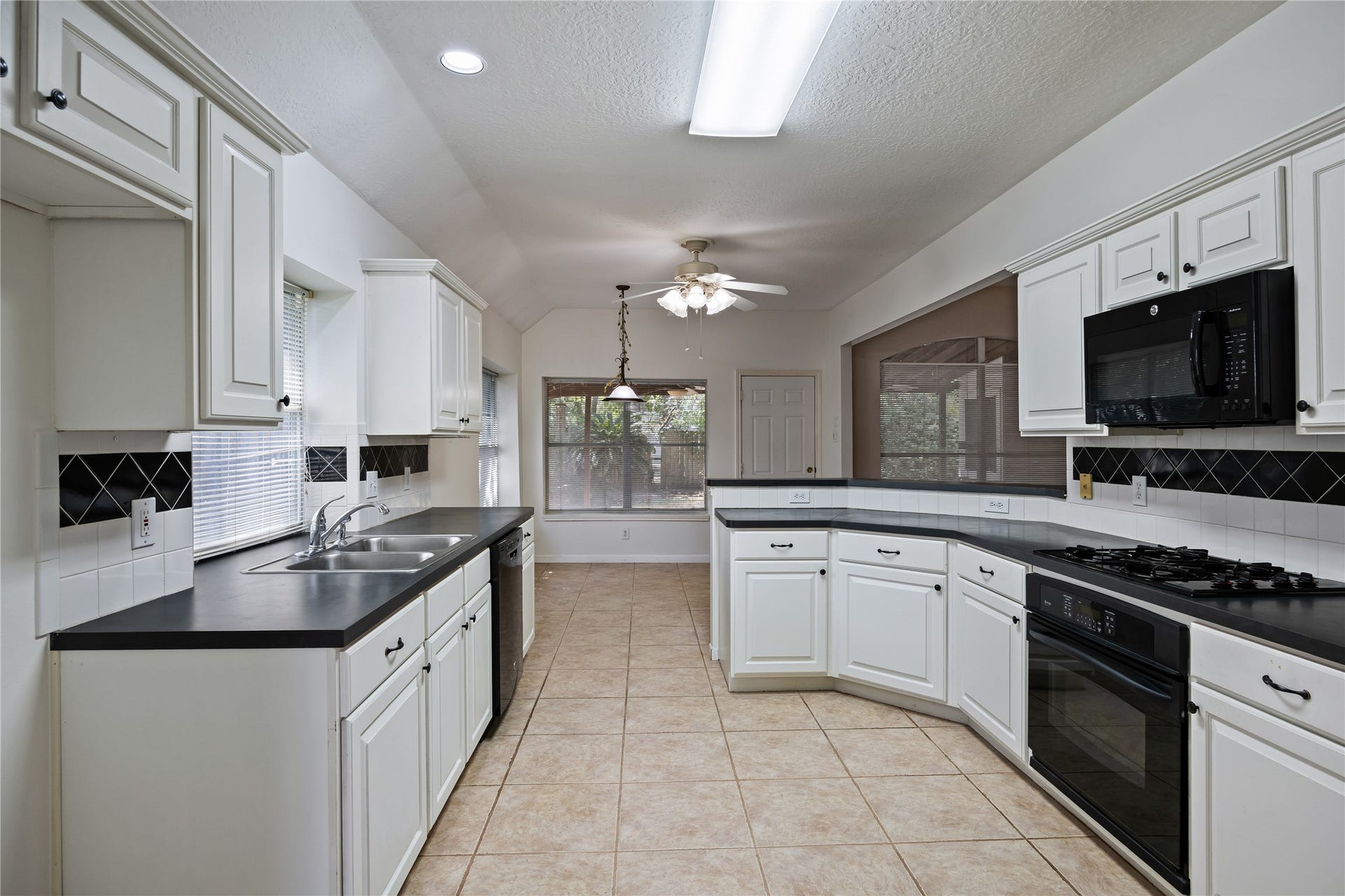 16926 Cobbler Crossing Drive, Sugar Land, TX 77498 Crisp white cabinetry and black accents give the kitchen a fresh, polished look, while the layout offers plenty of workspace and storage for everything from quick breakfasts to feeding a full house. The casual dining area and open bar keep meals and conversation flowing easily.