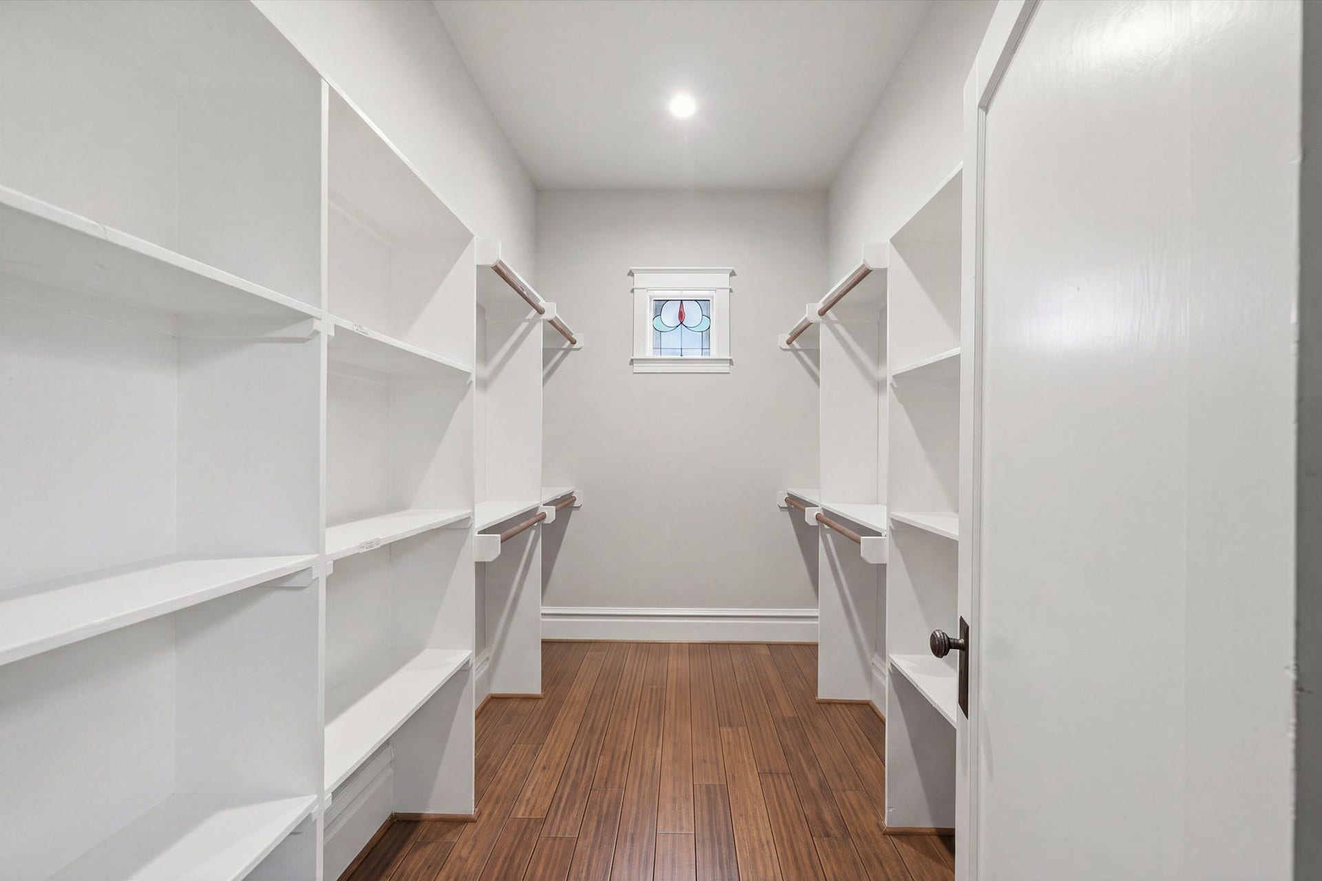 Good sized walk-in closet - plenty of room for hanging and stacking clothing! Stained glass window centers the space!