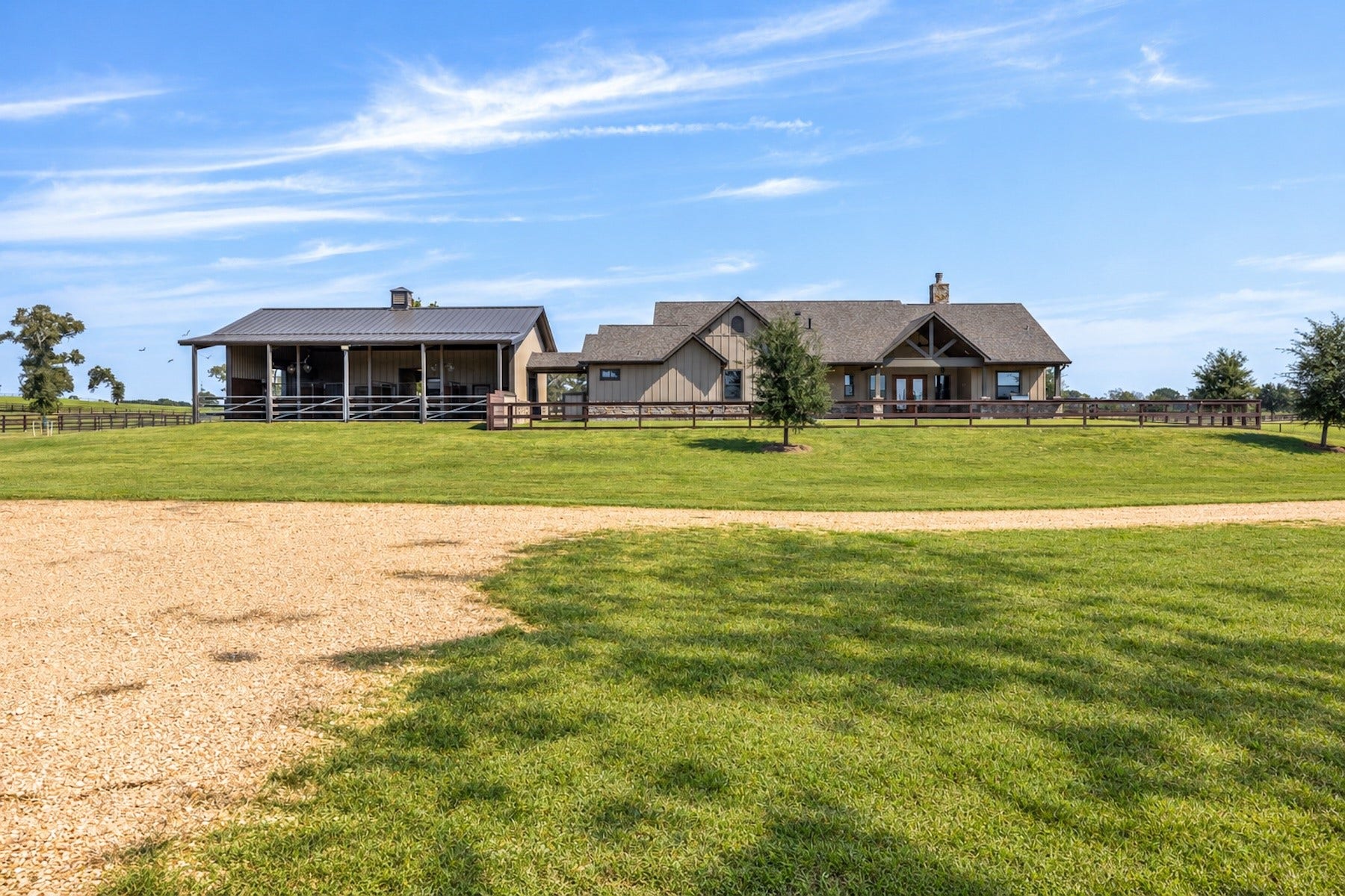 30163 High Spirit Ranch Road, Hempstead, TX 77445 Gravel road leads to the storage shed. In this view you'll see the backside of the home with attached stables and guest suite.