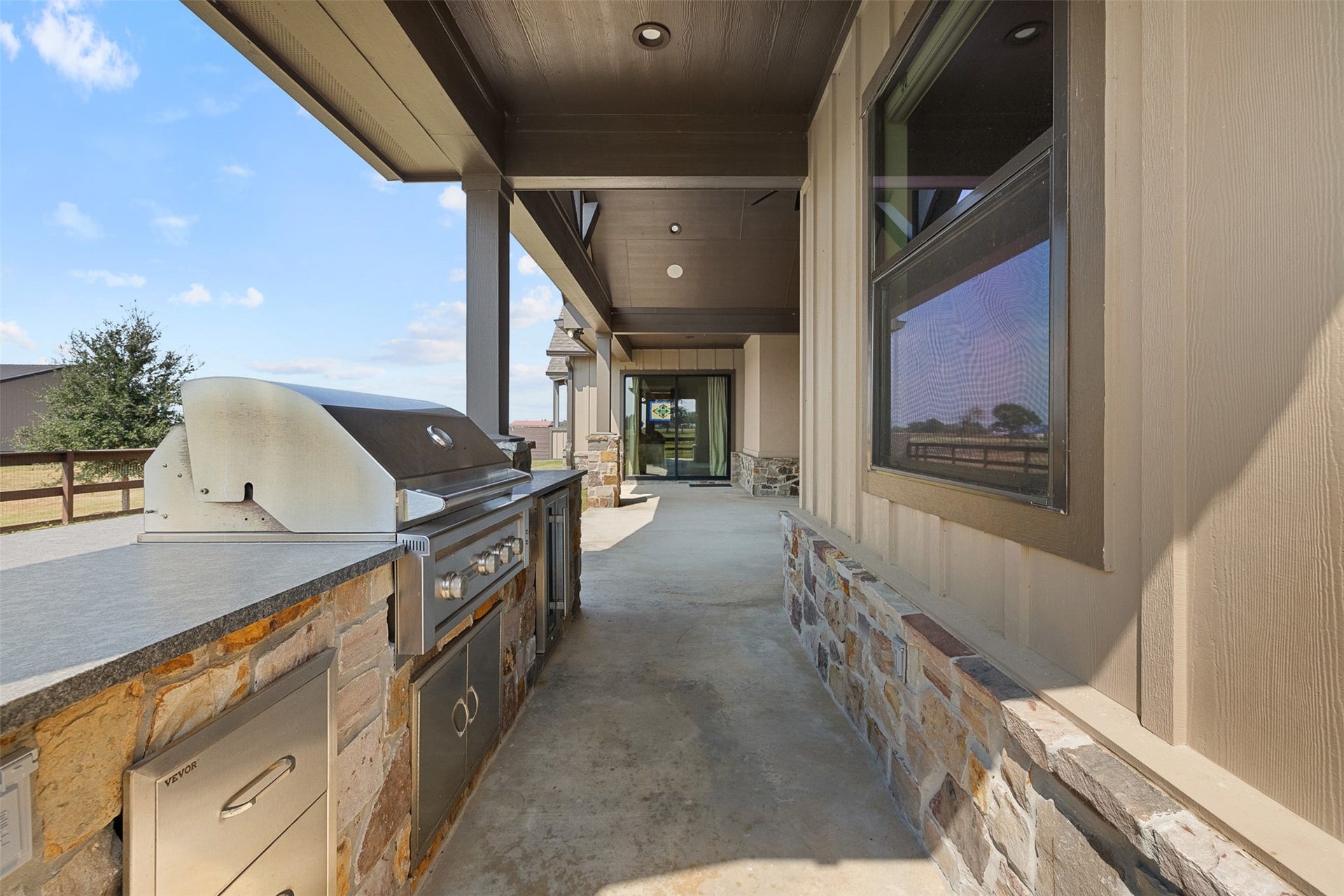 30163 High Spirit Ranch Road, Hempstead, TX 77445 The back porch of the home has an outdoor kitchen area with a grill, perfect for entertaining.