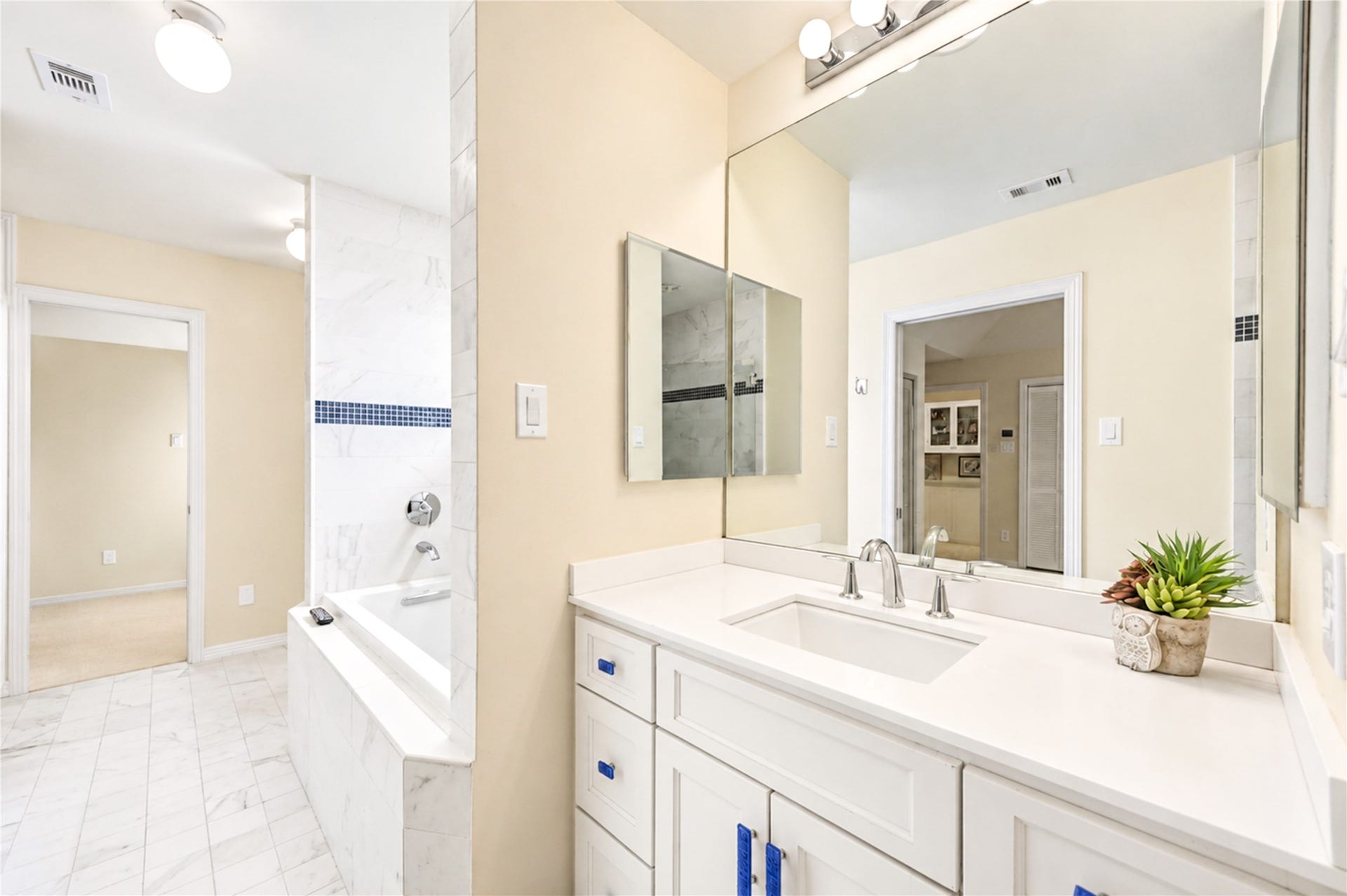 4 Milan Estates, Houston, TX 77056 A bright vanity, expansive mirror and beautiful blue-tile accents complement the soaking tub in this third-floor bathroom.