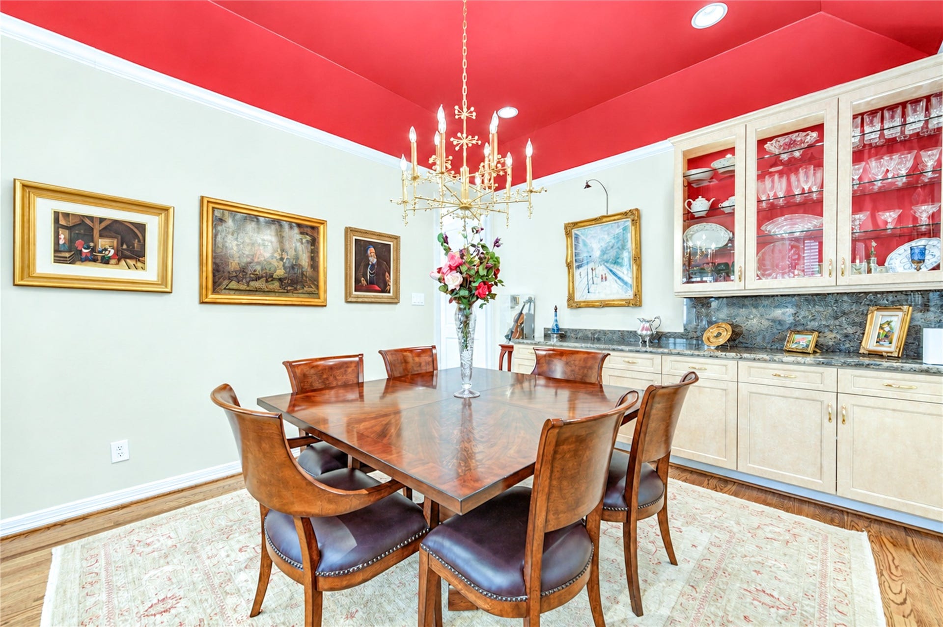 4 Milan Estates, Houston, TX 77056 Glass-front built-in cabinetry and a granite-topped buffet line the dining room wall beneath crown molding.