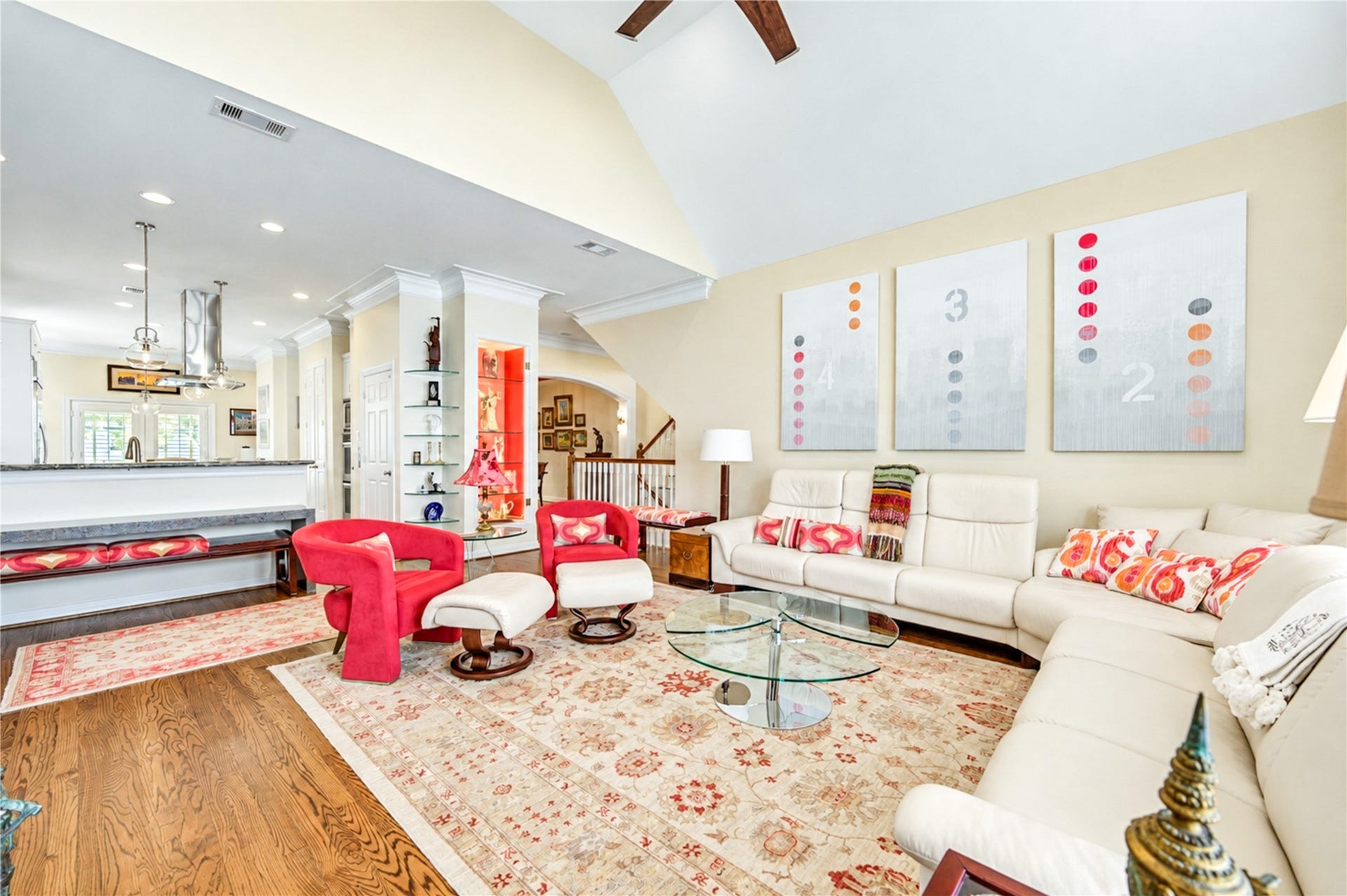 4 Milan Estates, Houston, TX 77056 An alternate view showcases the beautiful connection between the vaulted living room and kitchen, framed by architectural columns and warm hardwood flooring.