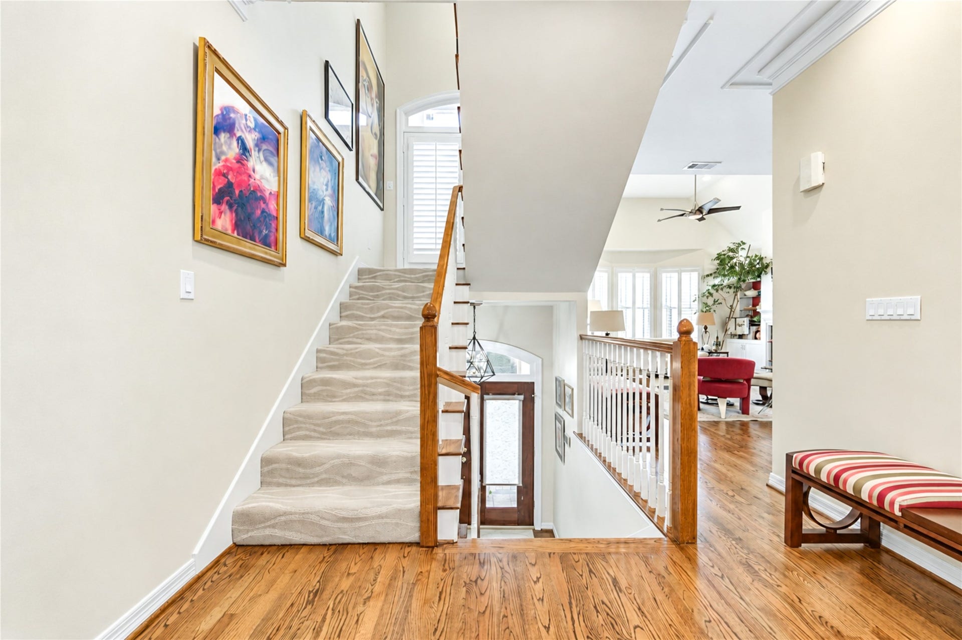 4 Milan Estates, Houston, TX 77056 A carpeted staircase with a turned wood railing connects the levels, with hardwood floors leading into the open living areas.