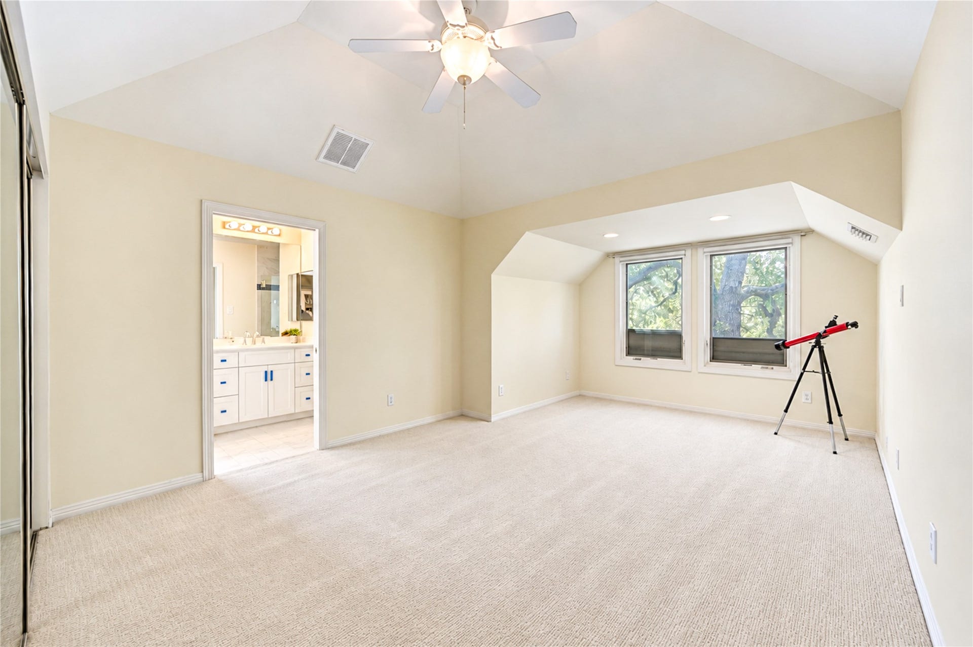 4 Milan Estates, Houston, TX 77056 A bright third-floor bedroom features a vaulted ceiling, a ceiling fan, tall windows and direct access to a bath.