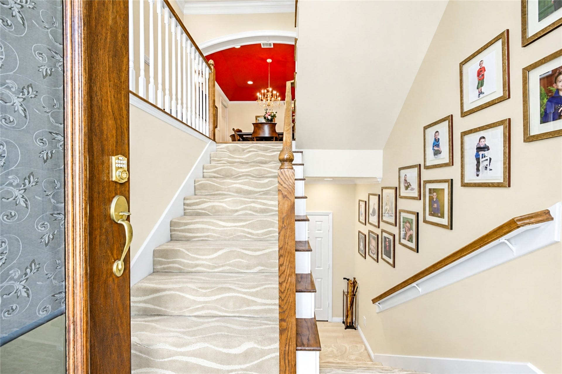 4 Milan Estates, Houston, TX 77056 A graceful staircase rises from the entry to the second-floor living areas, offering a glimpse of the dining room's striking red ceiling and chandelier.