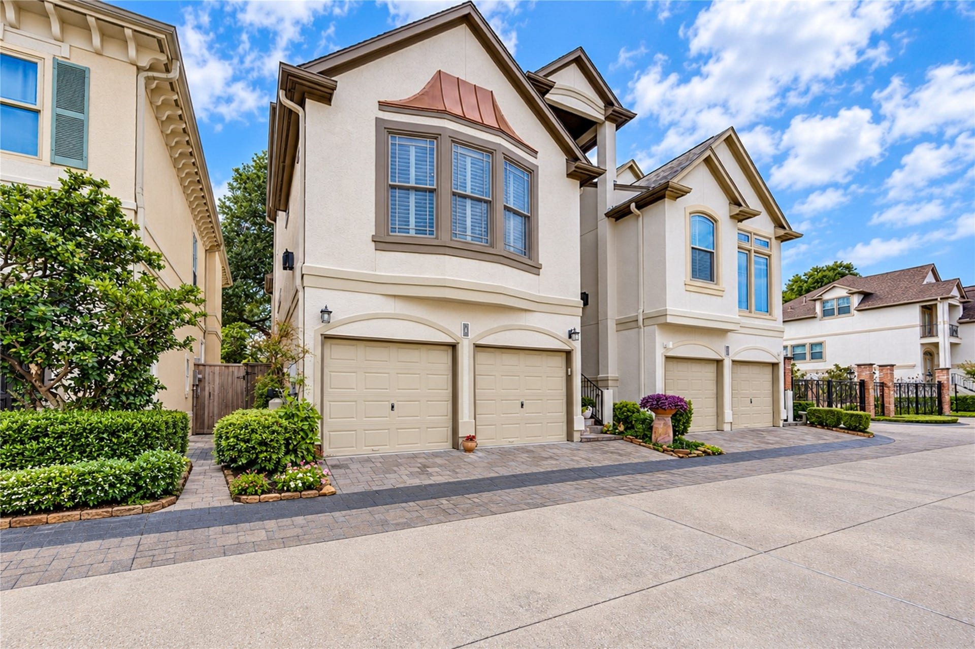 4 Milan Estates, Houston, TX 77056 An angled view highlights the elegant stucco exterior, arched garage openings and landscaped entrance to this distinctive three-story residence.