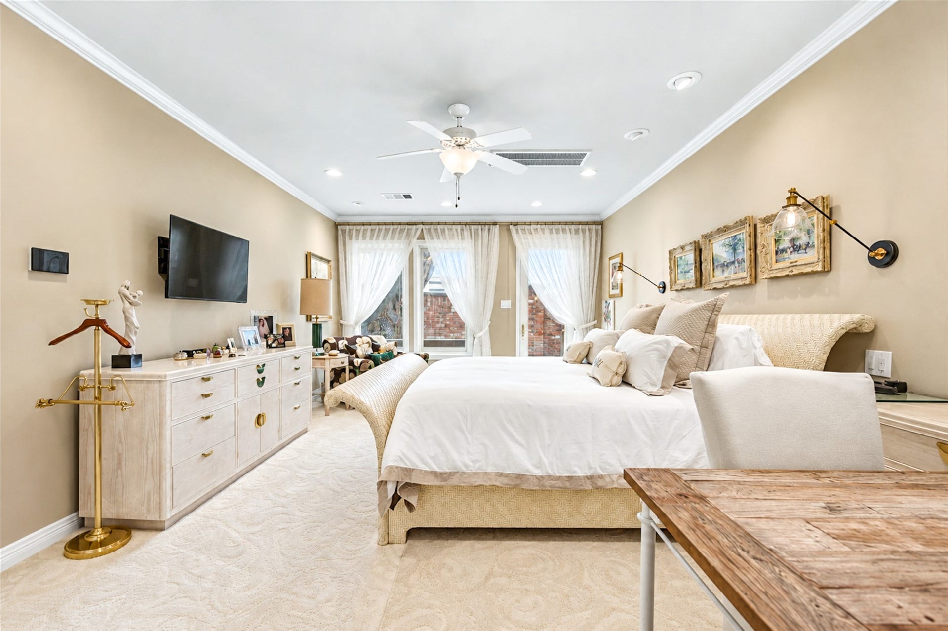4 Milan Estates, Houston, TX 77056 Large windows along one wall bring natural light into the first-floor primary bedroom, beneath a ceiling fan and recessed lighting.