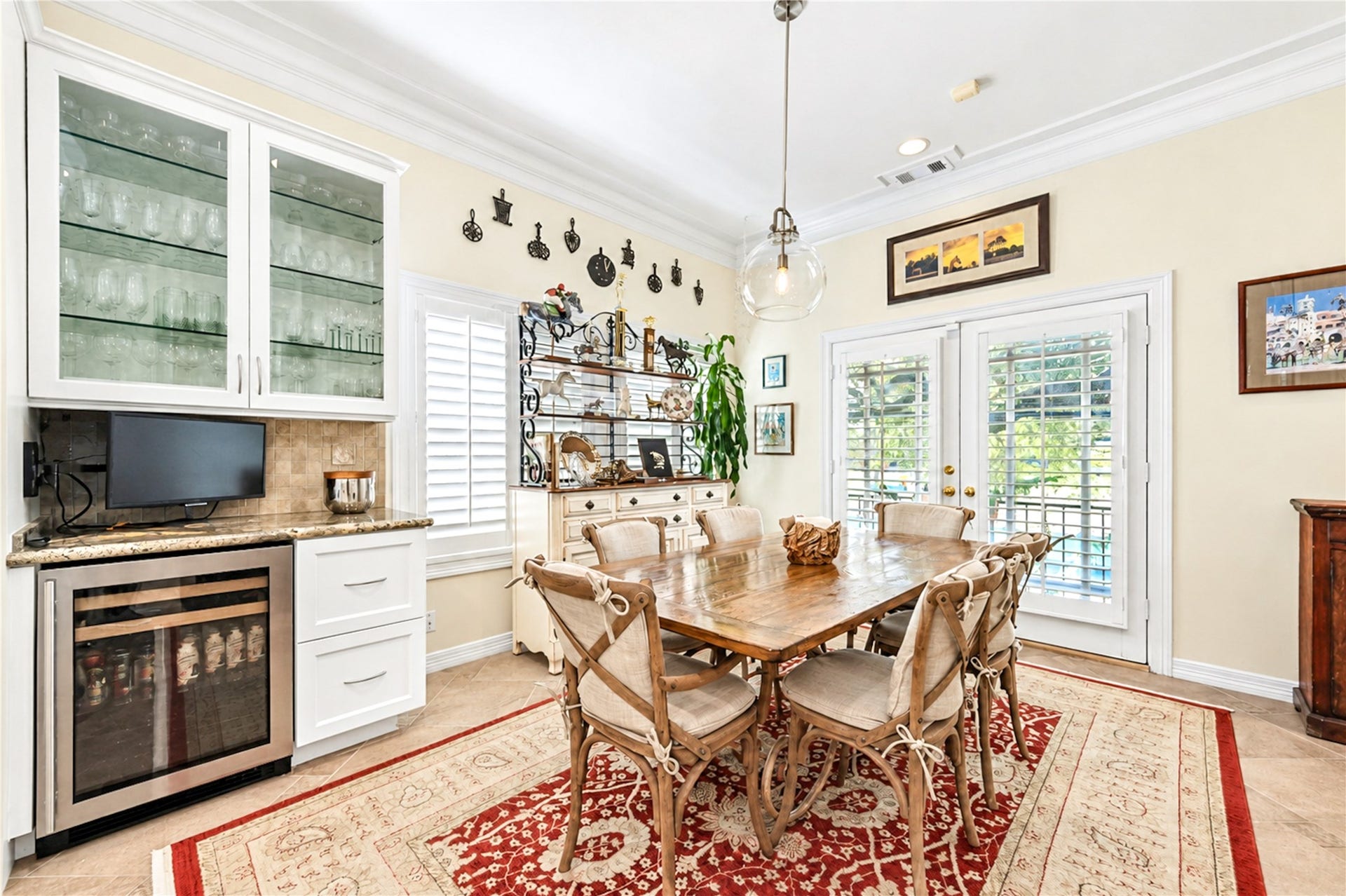 4 Milan Estates, Houston, TX 77056 A glass-front cabinet wall, a granite counter and a wine refrigerator sit beside French doors that bring natural light into the breakfast area.