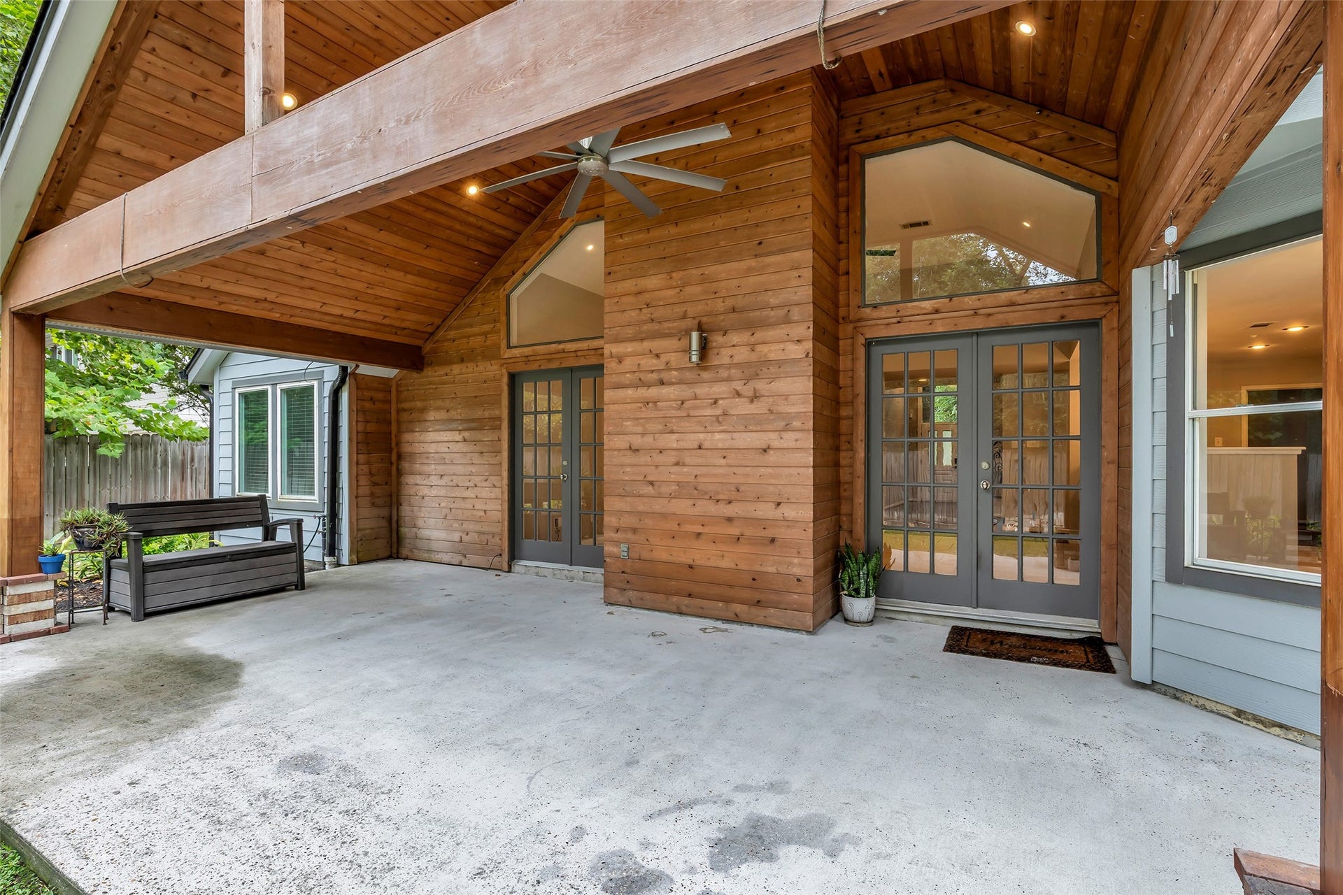 54 Sky Terrace Place, The Woodlands, TX 77381 Charming covered patio with vaulted wooden ceilings, dual French doors, and ample space for outdoor relaxation.