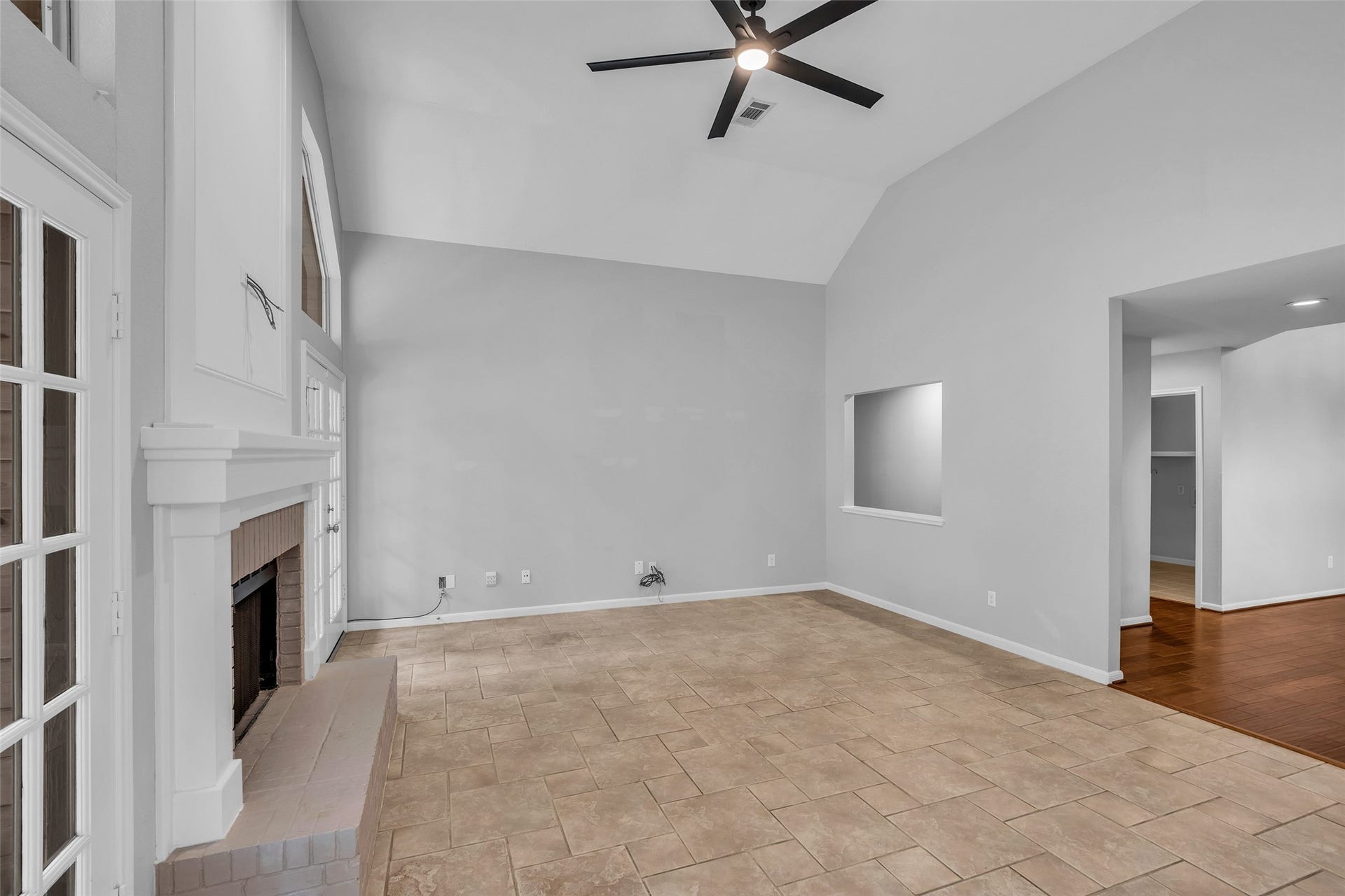 54 Sky Terrace Place, The Woodlands, TX 77381 Spacious second living area seamlessly connected to the kitchen, featuring soaring vaulted ceilings, a cozy fireplace, tile flooring, and beautiful views of the backyard, an inviting space for everyday living and entertaining.