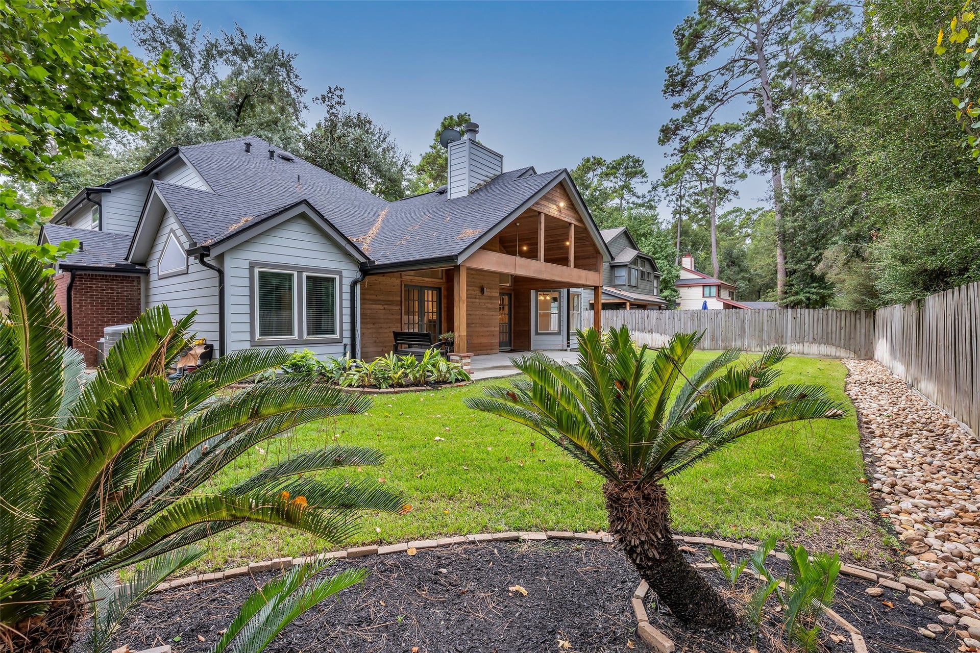 54 Sky Terrace Place, The Woodlands, TX 77381 Another view of the inviting backyard, highlighting the mature landscaping, covered patio, and peaceful outdoor setting ideal for relaxing or entertaining.