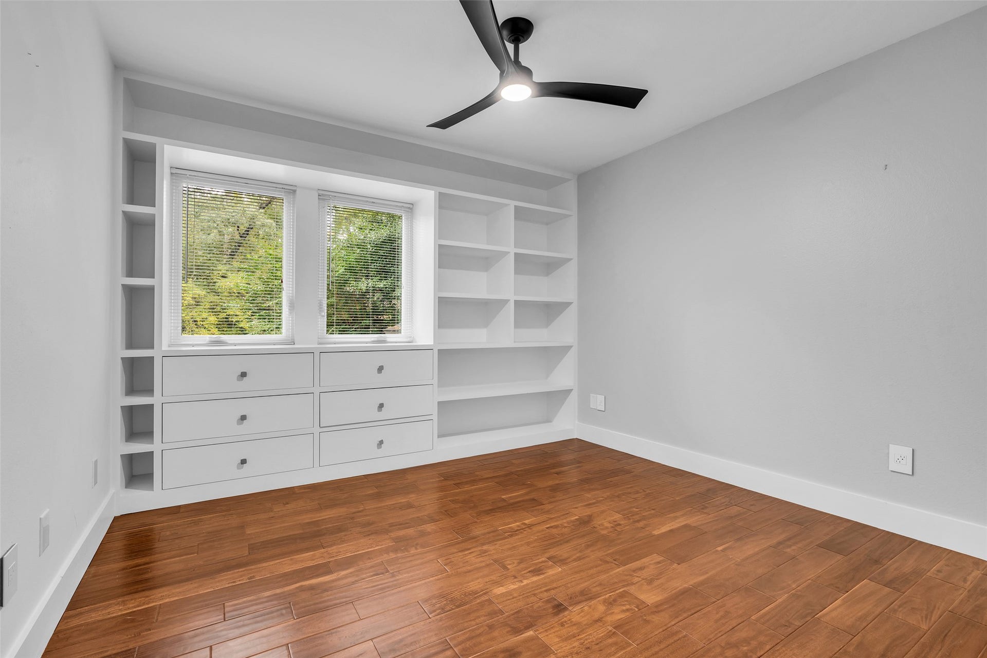 54 Sky Terrace Place, The Woodlands, TX 77381 Bright 4th room featuring elegant hardwood floors, built-in shelving, ample storage drawers, and a sleek ceiling fan.
