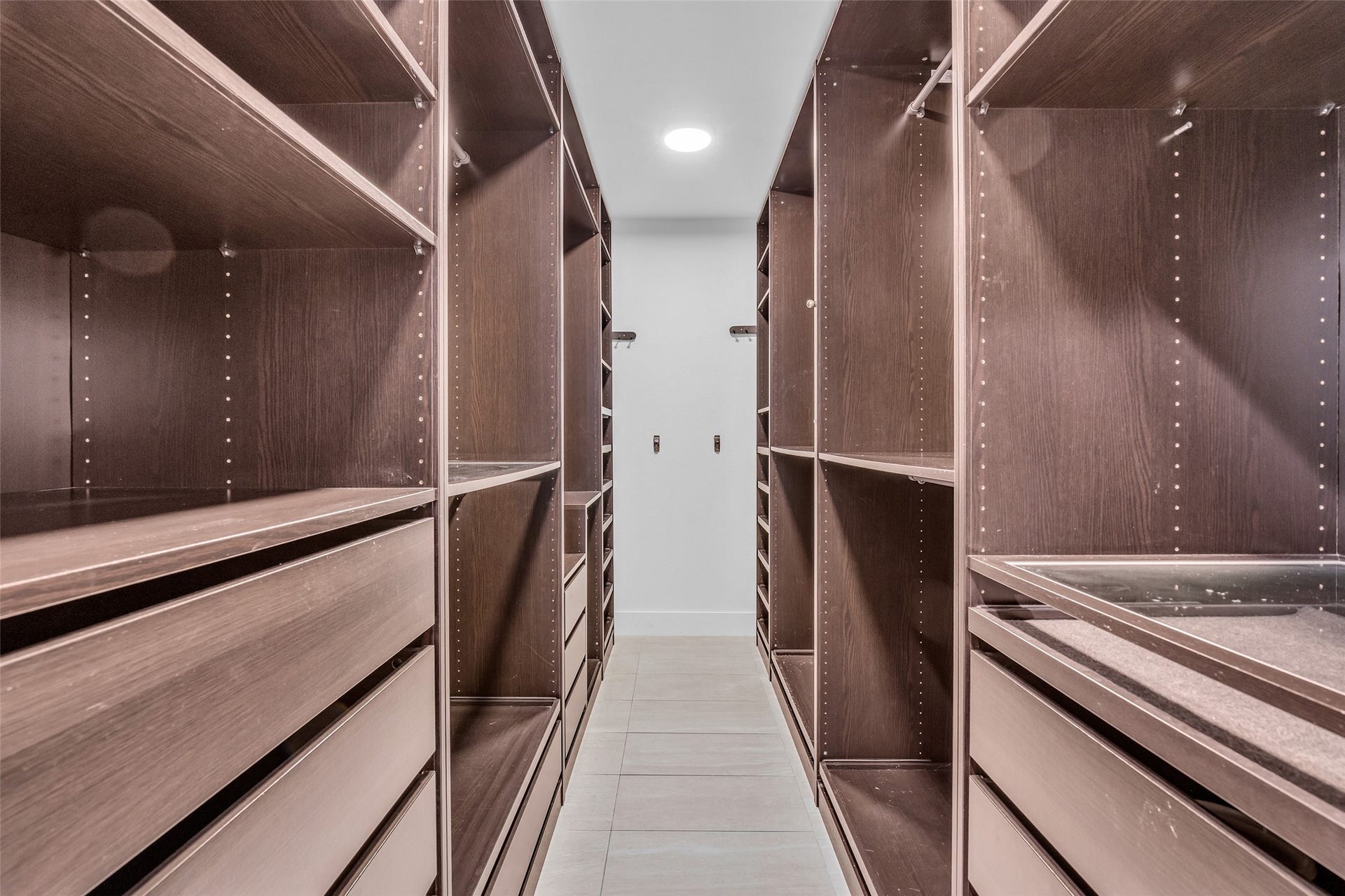 54 Sky Terrace Place, The Woodlands, TX 77381 Spacious walk-in closet featuring custom dark wood shelving and ample storage options, perfect for organizing your wardrobe.