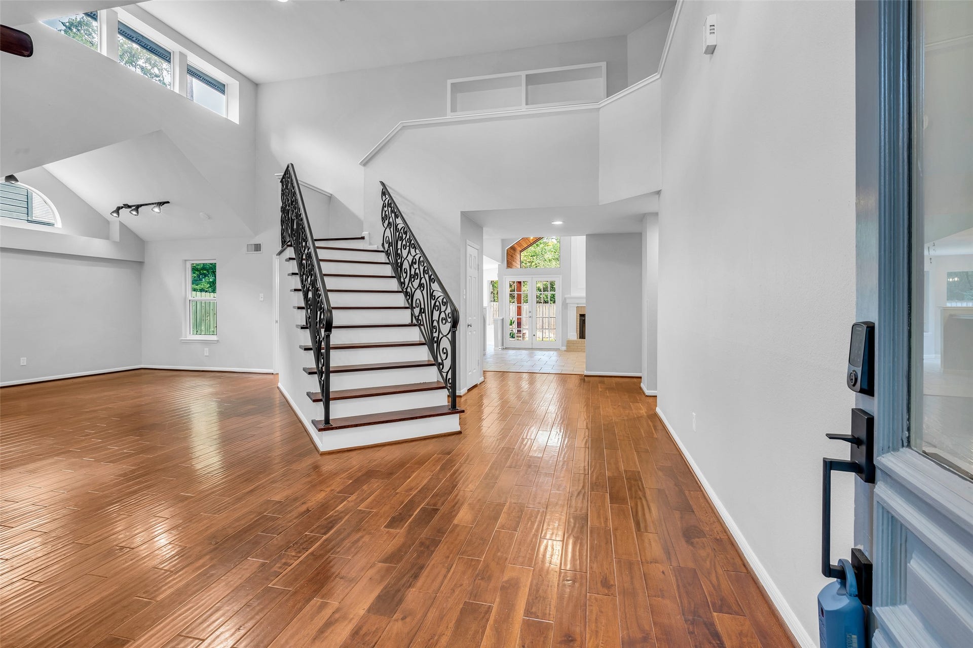 54 Sky Terrace Place, The Woodlands, TX 77381 View from the main entry showcasing the seamless flow and functionality of the floor plan, with open living spaces, high ceilings, beautiful hardwood floors, and abundant natural light throughout.
