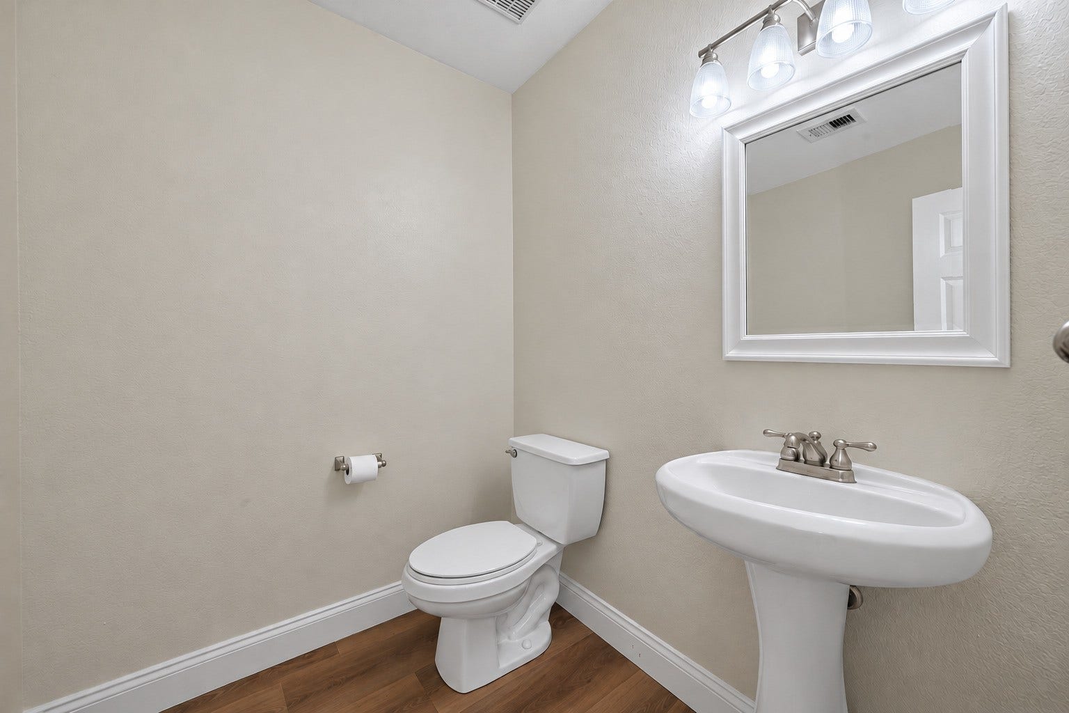 2662 Skyview Glen Court, Houston, TX 77047 A pedestal sink, well-lit mirror, and streamlined fixtures give this main-level powder room a neat, uncluttered finish, offering a practical stop for guests.