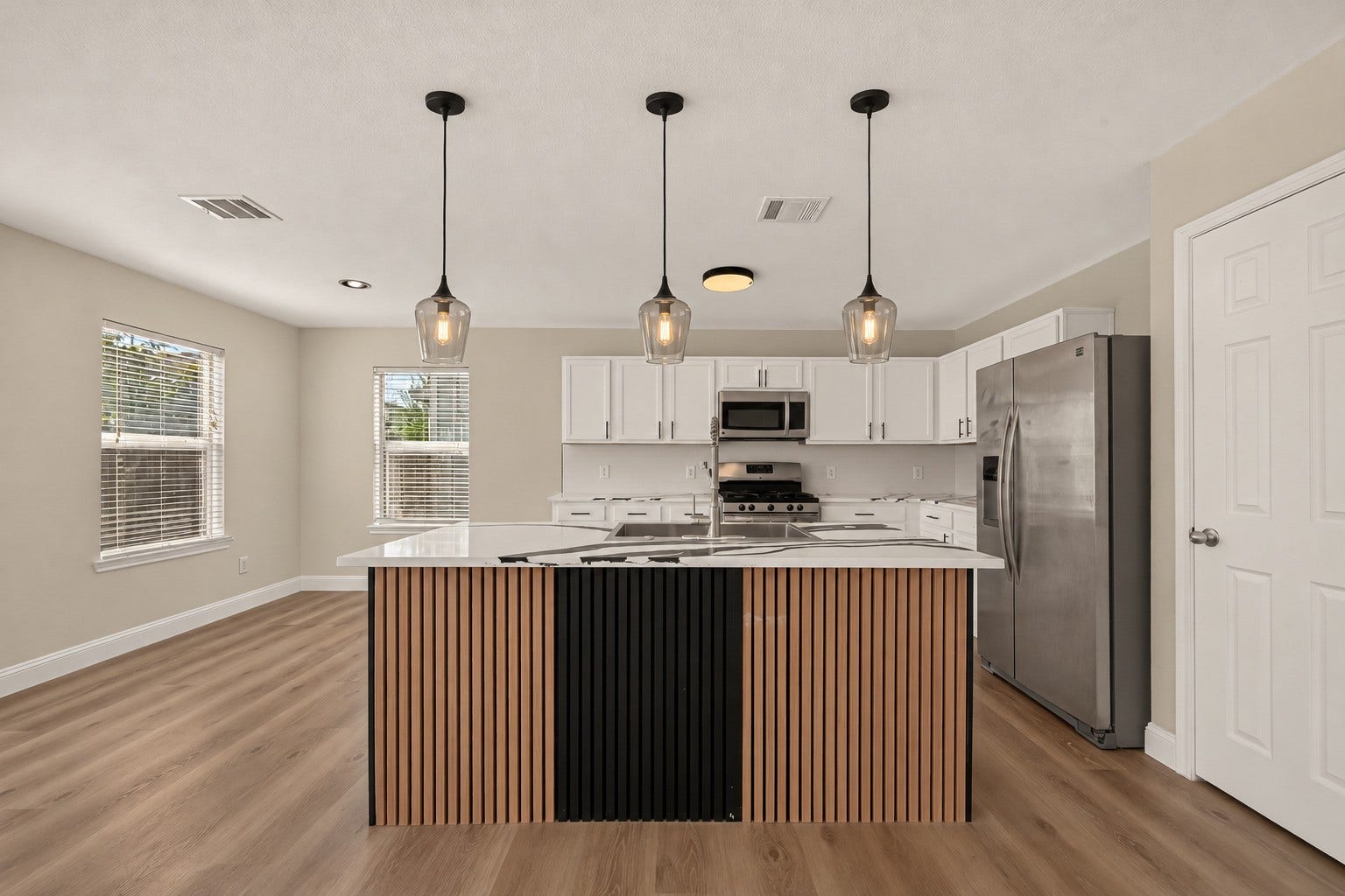 2662 Skyview Glen Court, Houston, TX 77047 A substantial central island anchors the kitchen beneath pendant lighting, while abundant white cabinetry lines the walls to keep storage close at hand. Clean finishes and ample work surfaces give the renovated space a fresh, contemporary look.