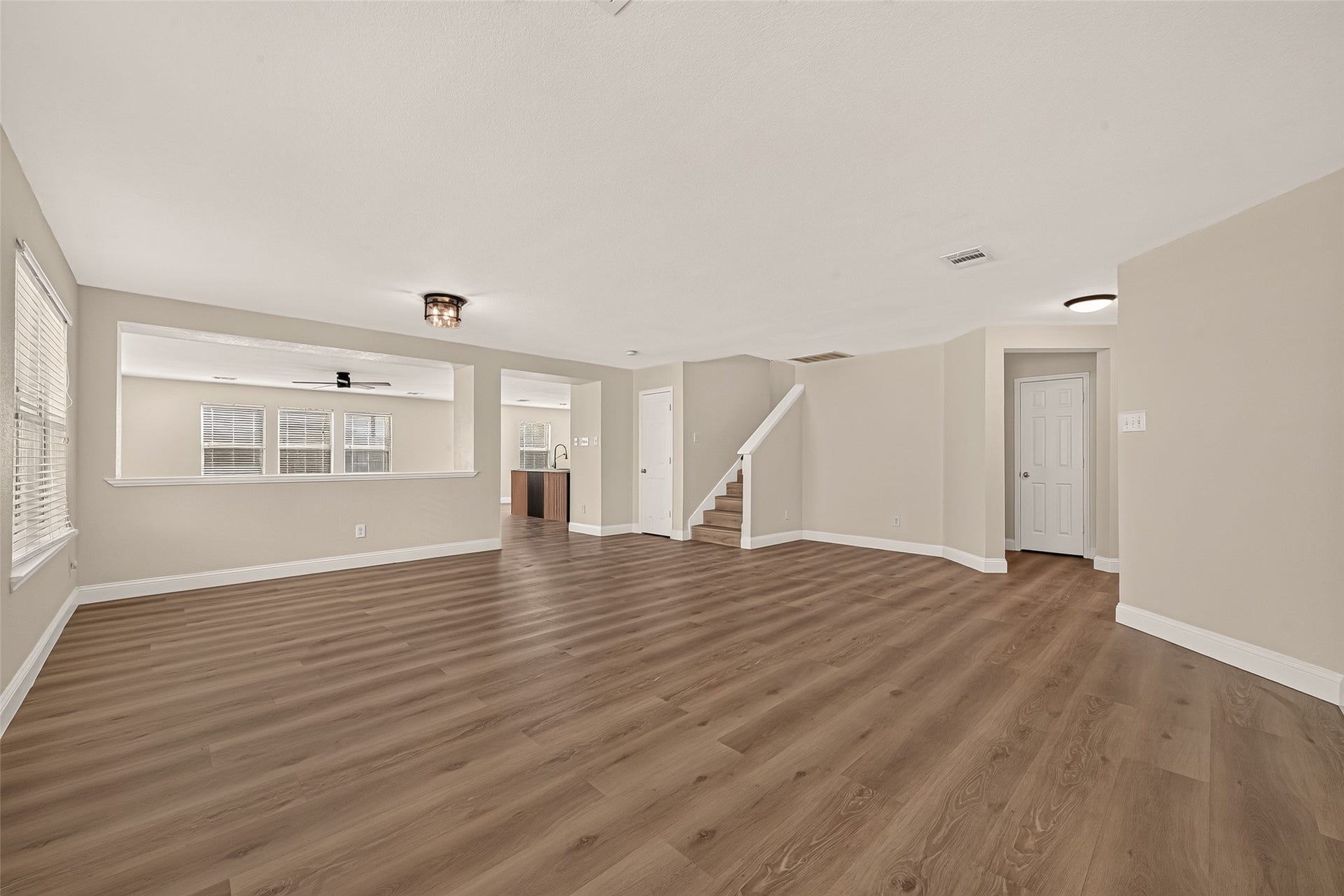 2662 Skyview Glen Court, Houston, TX 77047 An expansive, open space offers the flexibility to create distinct living and dining arrangements. Natural light pours through the large windows, highlighting the warm wood-look flooring and providing a bright foundation for a variety of furniture layouts.