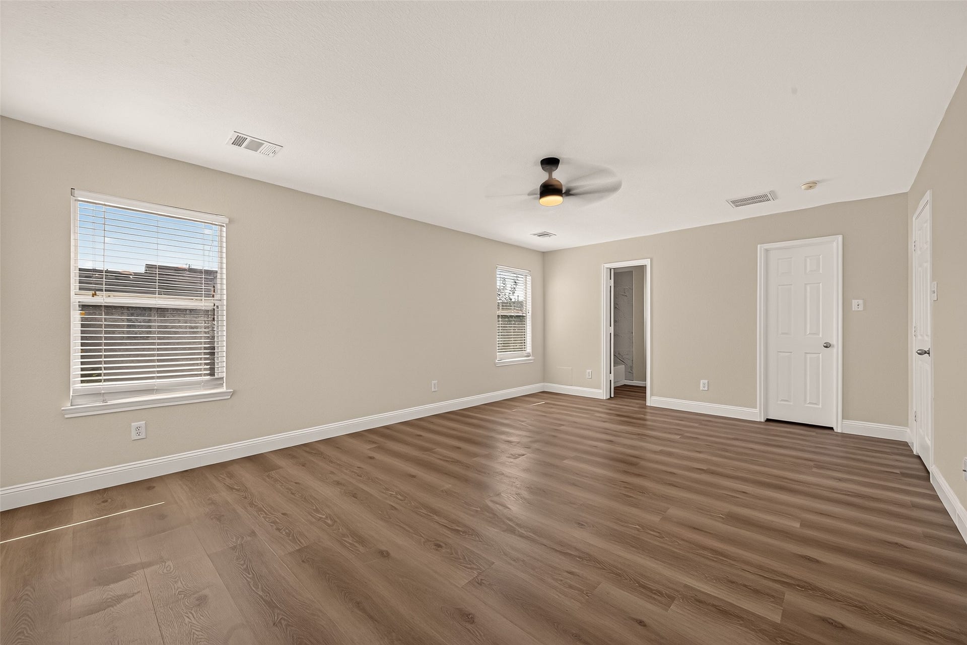 2662 Skyview Glen Court, Houston, TX 77047 Large windows brighten this expansive bedroom, giving the room an airy quality throughout the day. A ceiling fan adds comfort, while the ample floor space leaves plenty of room to arrange furnishings and create a personal haven.