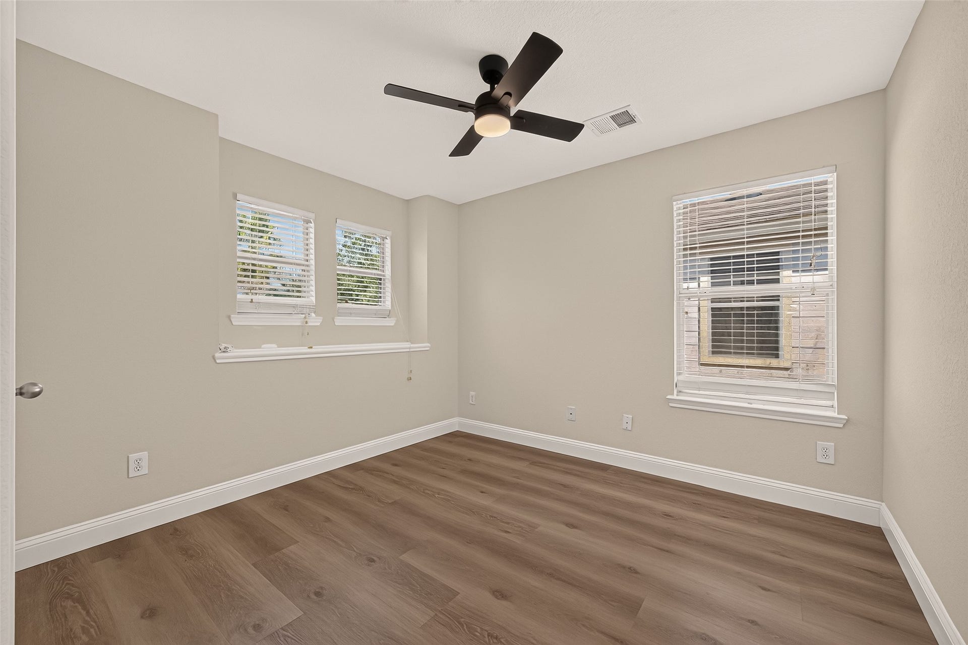 2662 Skyview Glen Court, Houston, TX 77047 Multiple windows bring daylight into this comfortably sized bedroom, complementing the cool neutral palette and warm-toned flooring. A ceiling fan adds everyday convenience while the understated finishes allow for a range of decorating styles.