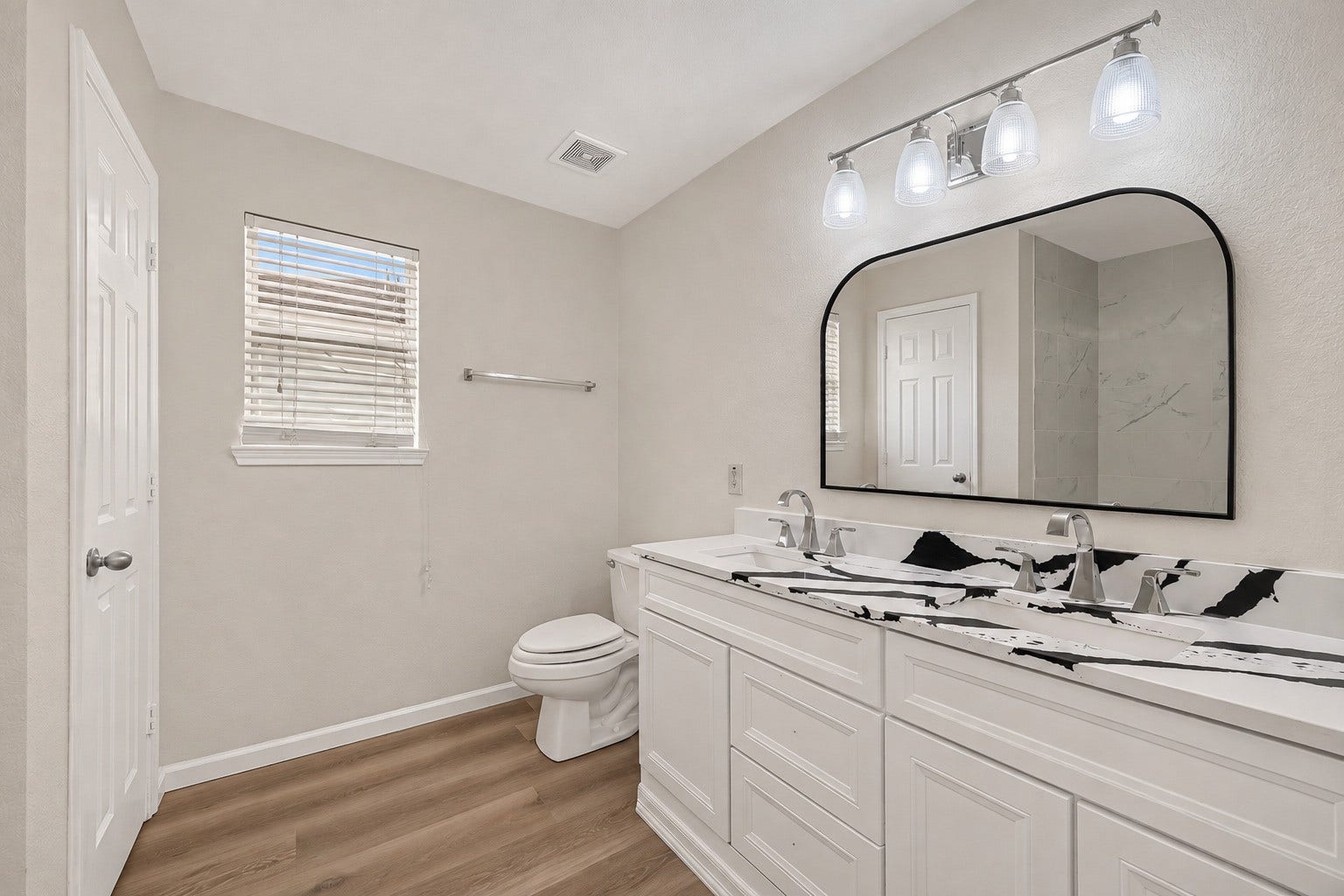 2662 Skyview Glen Court, Houston, TX 77047 A modern dual-sink vanity offers separate preparation space, complemented by a striking countertop and a window that welcomes daylight into the primary bath.