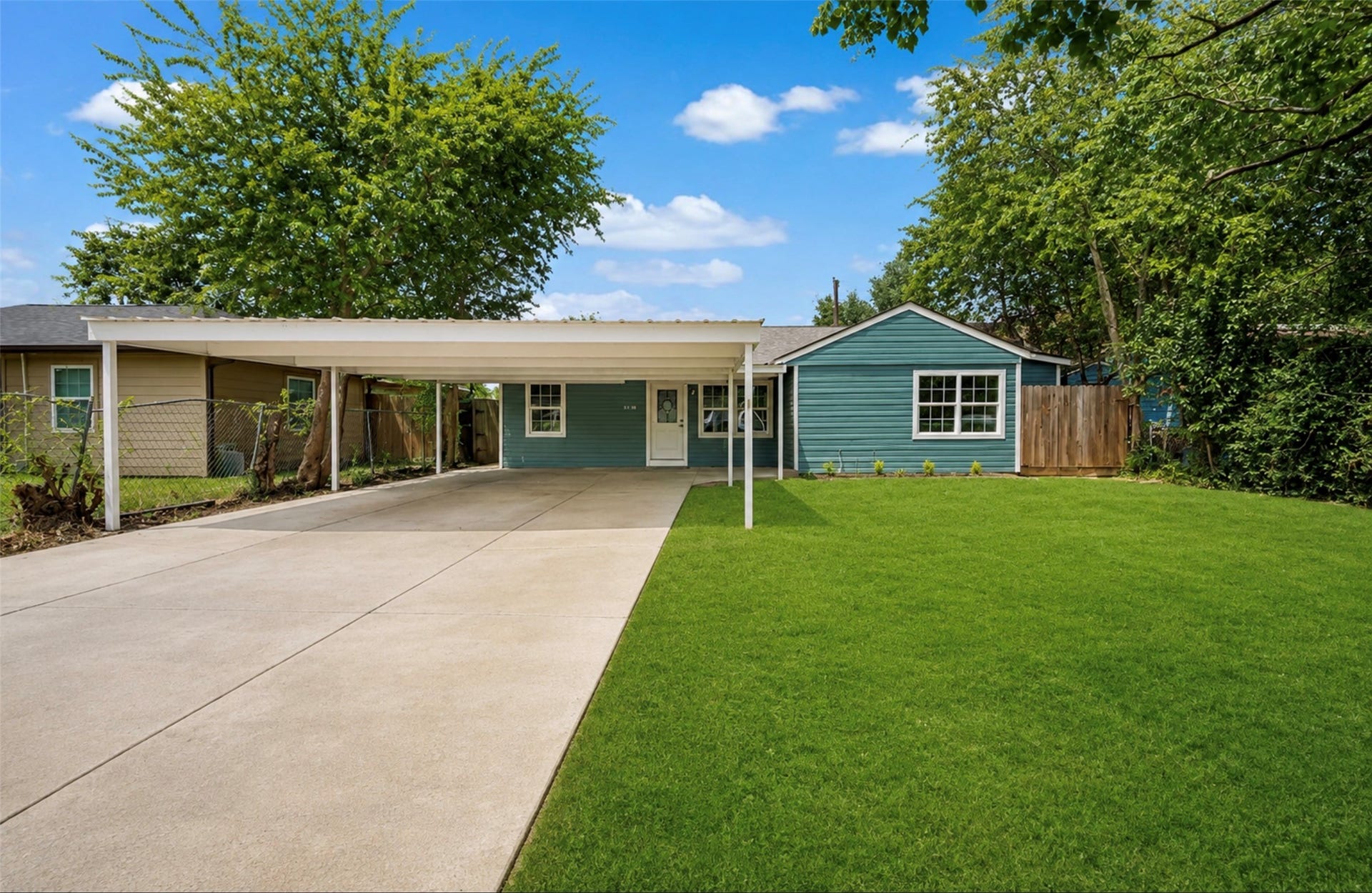 6638 Thornwall Street, Houston, TX 77092 Photoshopped/Enhanced Photo: Front view of this beautifully remodeled home showcasing ample driveway parking and a covered carport, providing convenient shade and protection from the Texas sun while helping keep the front of the home cooler.