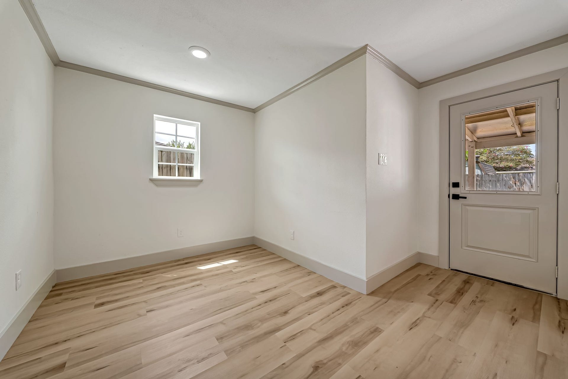 6638 Thornwall Street, Houston, TX 77092 Bright and inviting room with sleek LVP floors, neutral walls, and a door leading to an outdoor space.