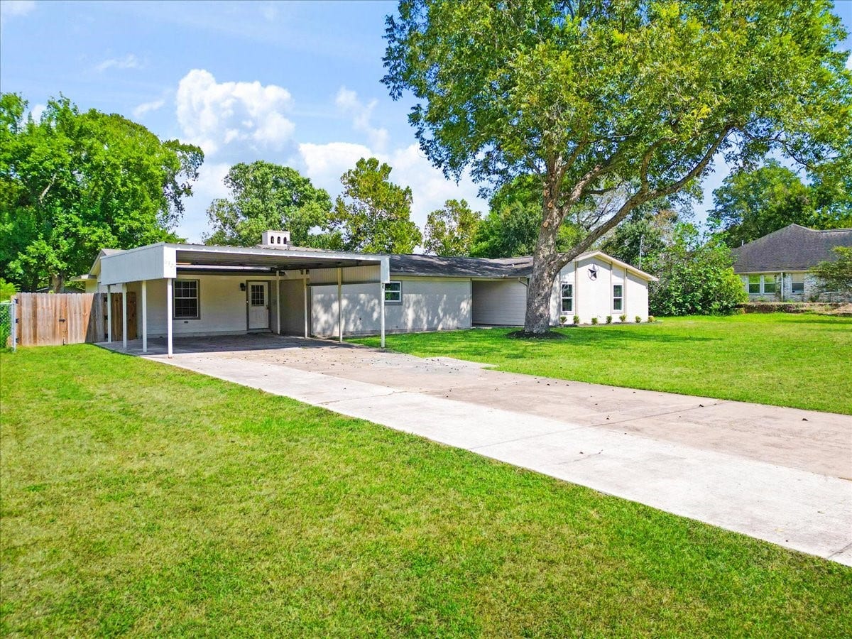 6327 Westcreek Drive, Brookside, TX 77581 Additional front exterior view highlighting the extended driveway, covered parking, and generous front lawn