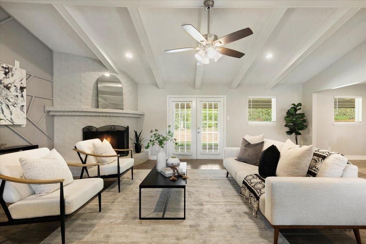 6327 Westcreek Drive, Brookside, TX 77581 Step into this stunning living room featuring a cozy fireplace, beautiful ceiling beams, and abundant natural light. A welcoming space to relax and gather