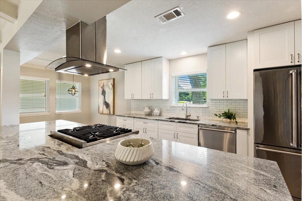 6327 Westcreek Drive, Brookside, TX 77581 Stunning kitchen featuring granite countertops, white cabinetry, stainless steel appliances, and a spacious island with gas cooktop.