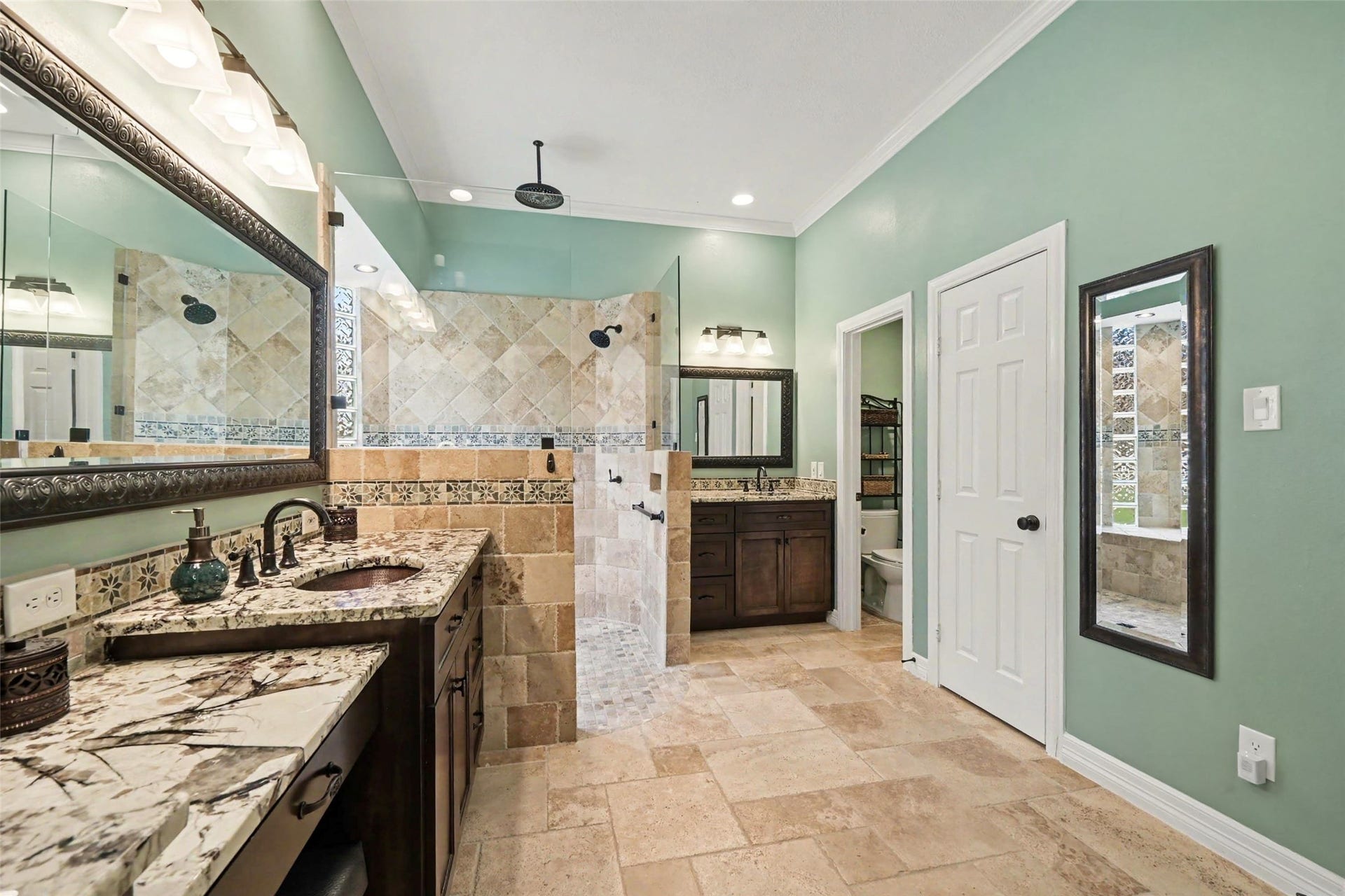 2907 Winding Shore Lane, Katy, TX 77450 UPDATED! Spacious bathroom featuring a luxurious dual-sink vanity with elegant granite countertops and a large walk-in shower adorned with intricate tile work.