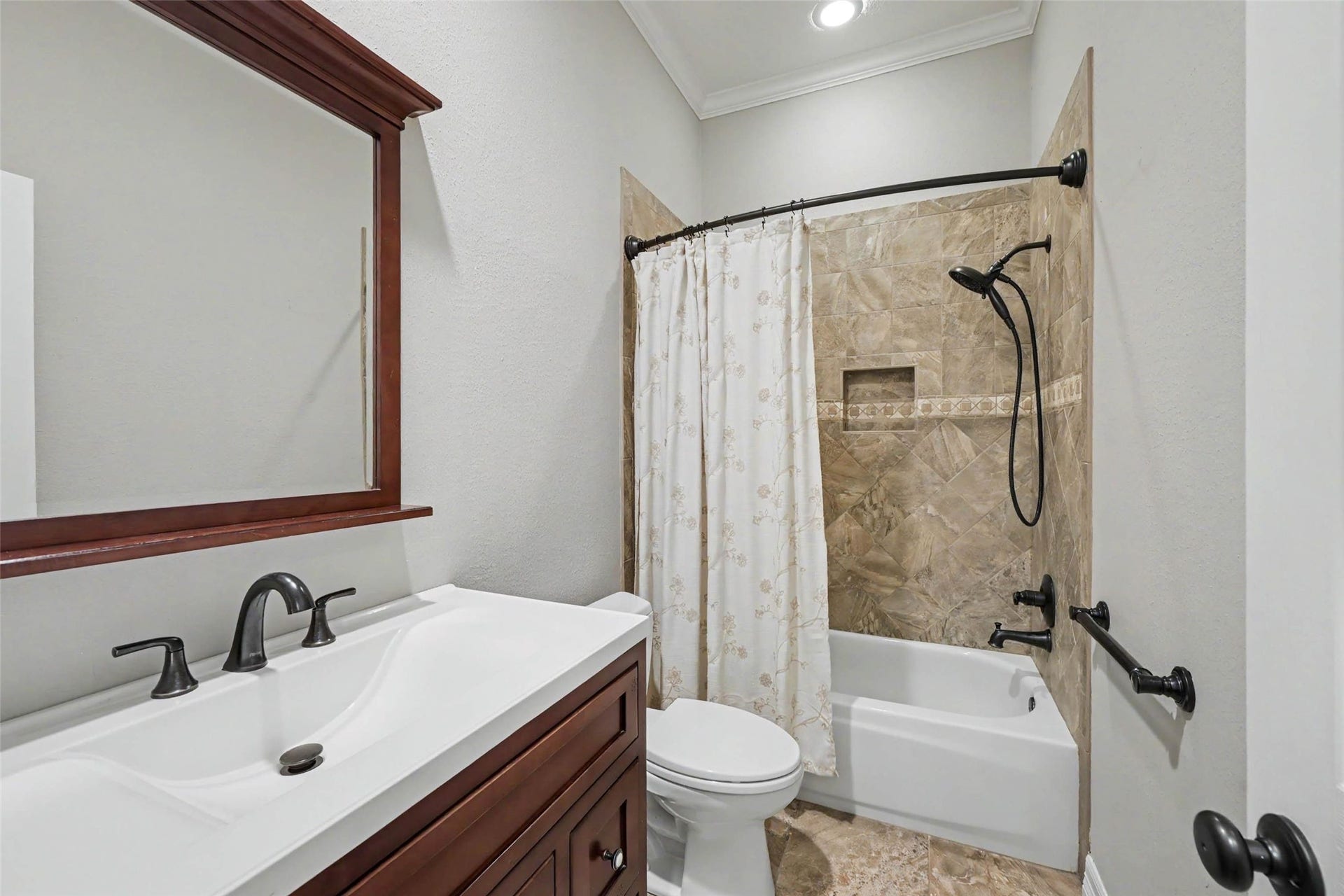 2907 Winding Shore Lane, Katy, TX 77450 Charming bathroom featuring a stylish vanity with a dark wood finish, elegant fixtures, and a tub-shower combo with beautiful tile surround.