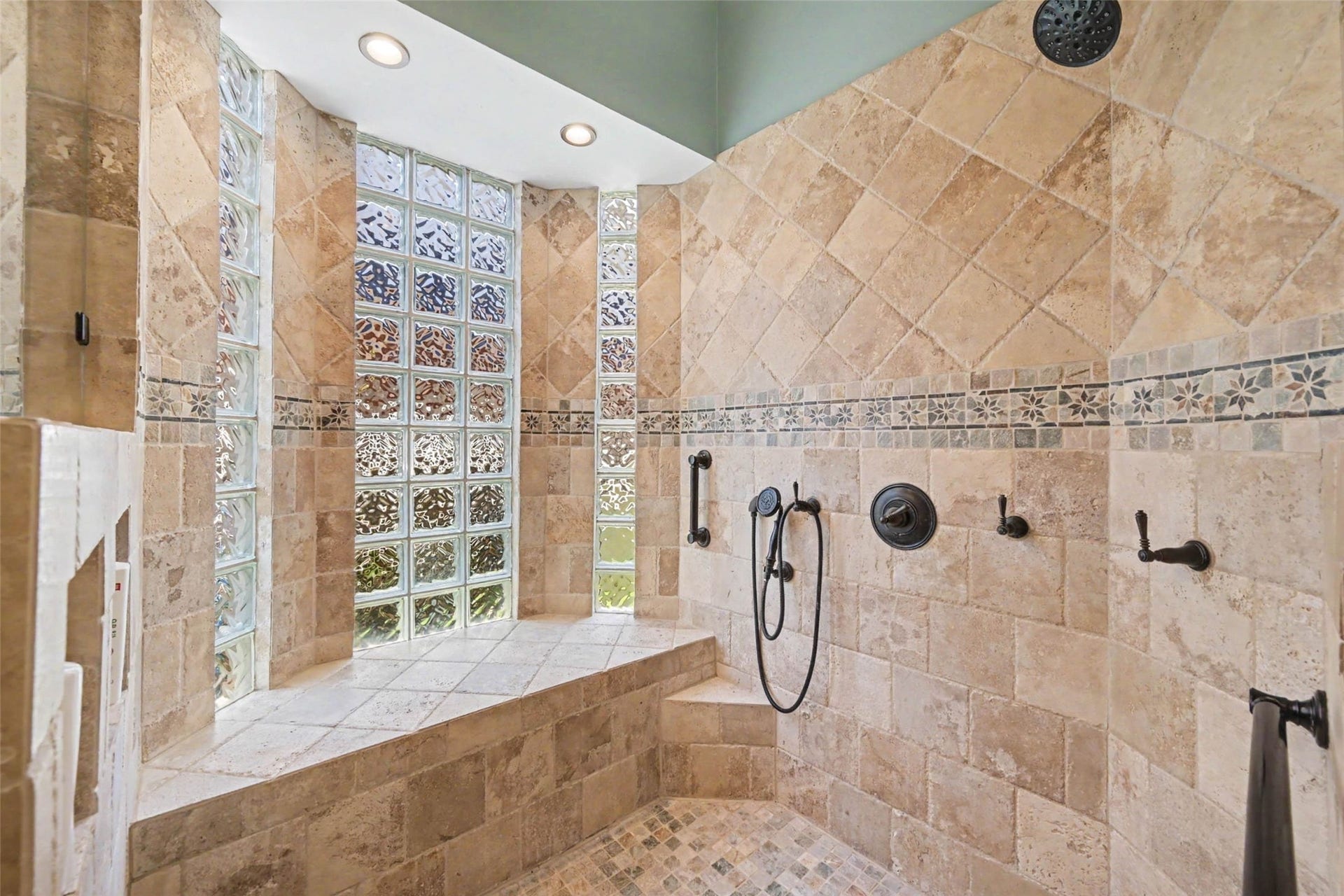 2907 Winding Shore Lane, Katy, TX 77450 UPDATED! Retreat to a luxurious spa-like shower featuring elegant tile surrounds, multiple shower heads, and beautiful glass block accents that allow natural light to fill the space. A stunning combination of style and functionality creates the perfect relaxing escape.